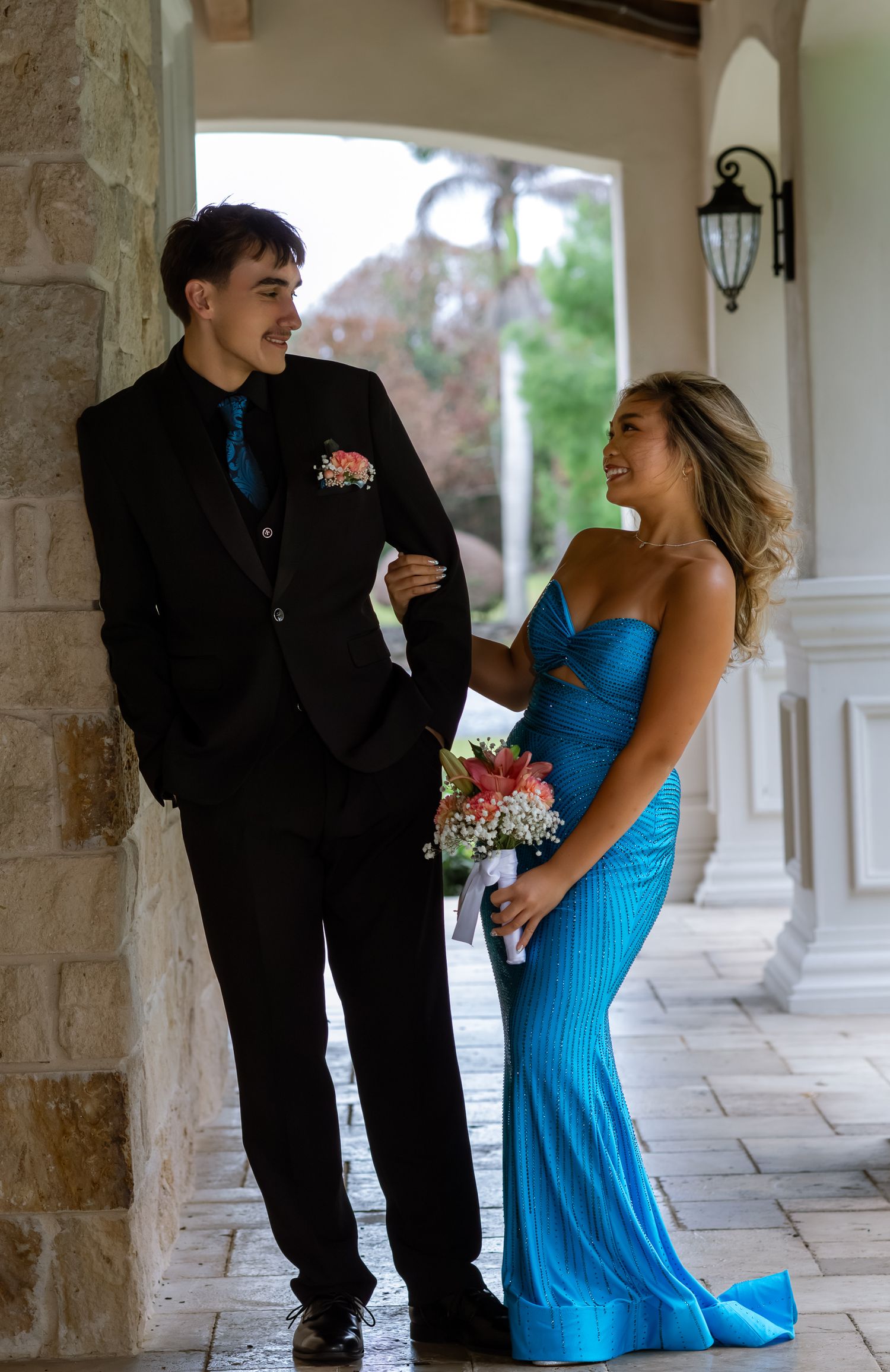 Young couple dressed formally posing together outdoors