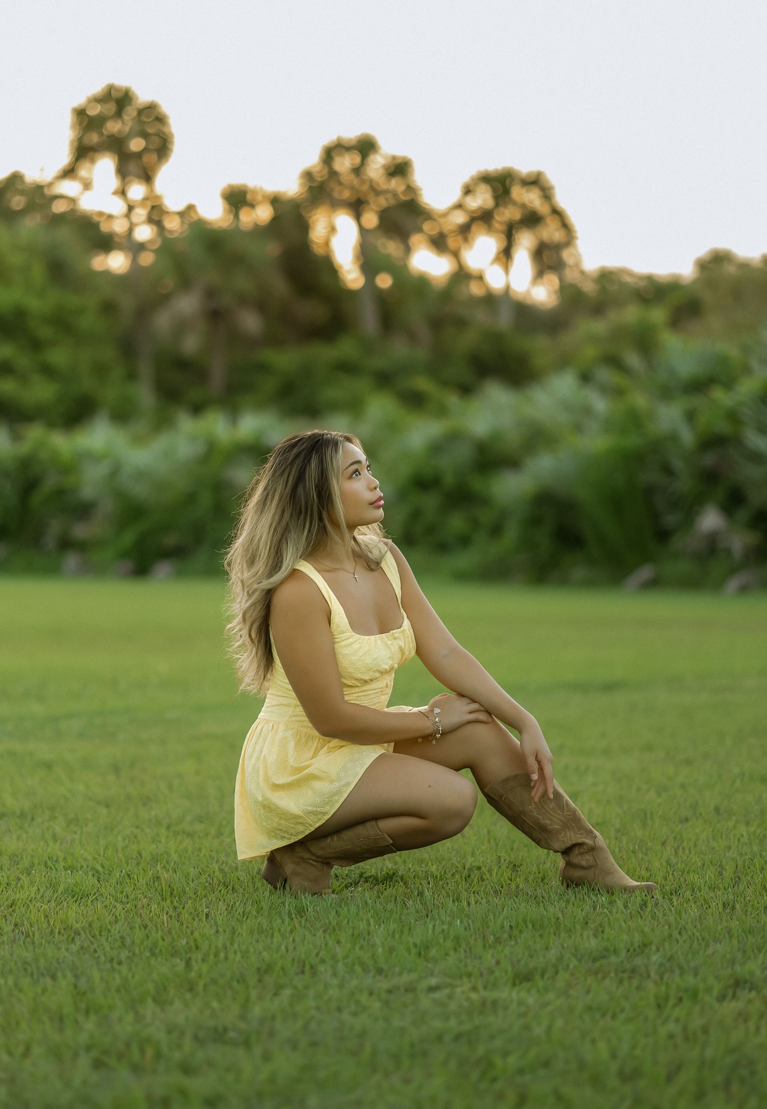 Young woman posing in a grassy field during an outdoor portrait session