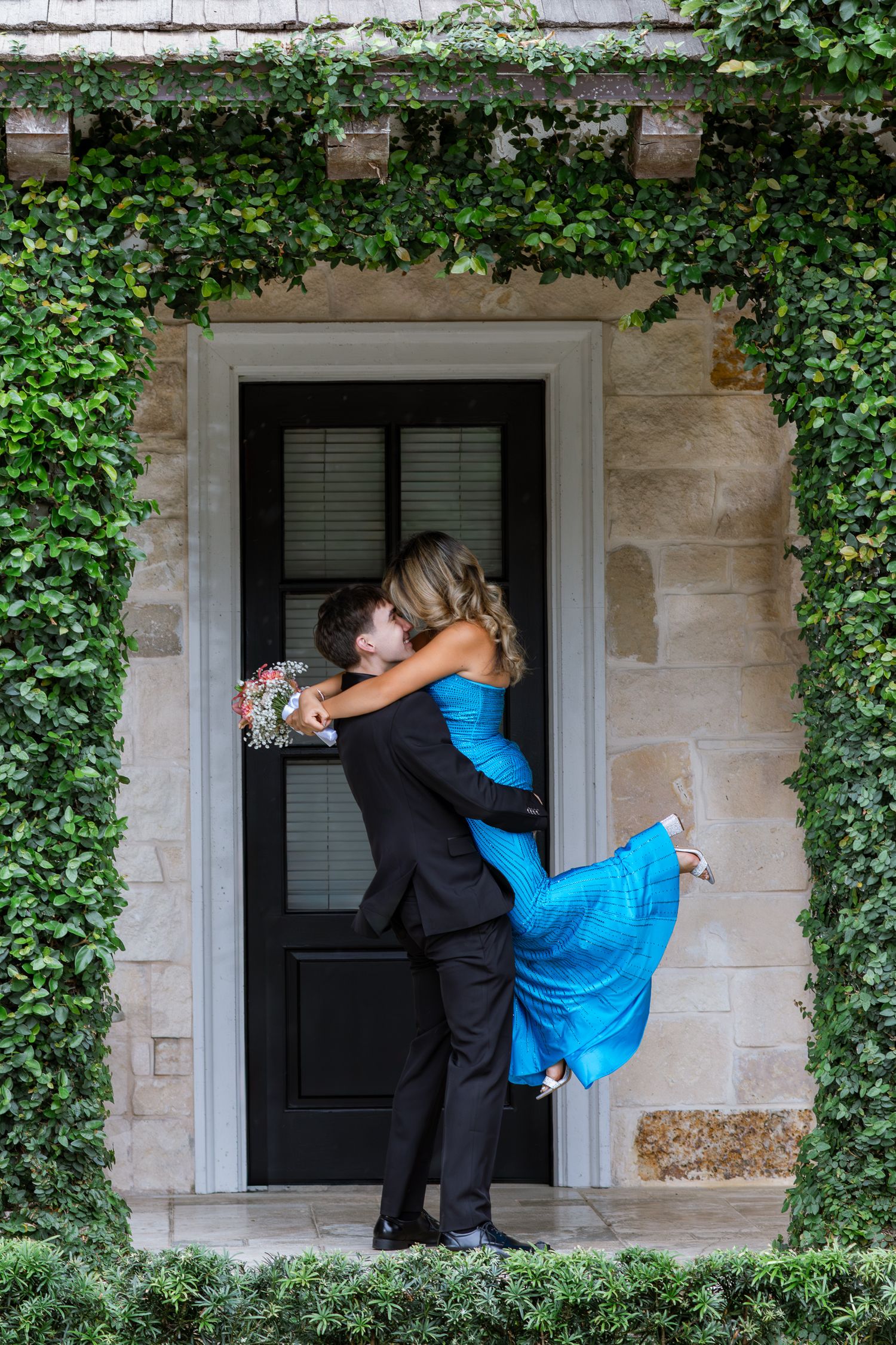Couple portrait with a man in a black suit and woman in a blue formal dress