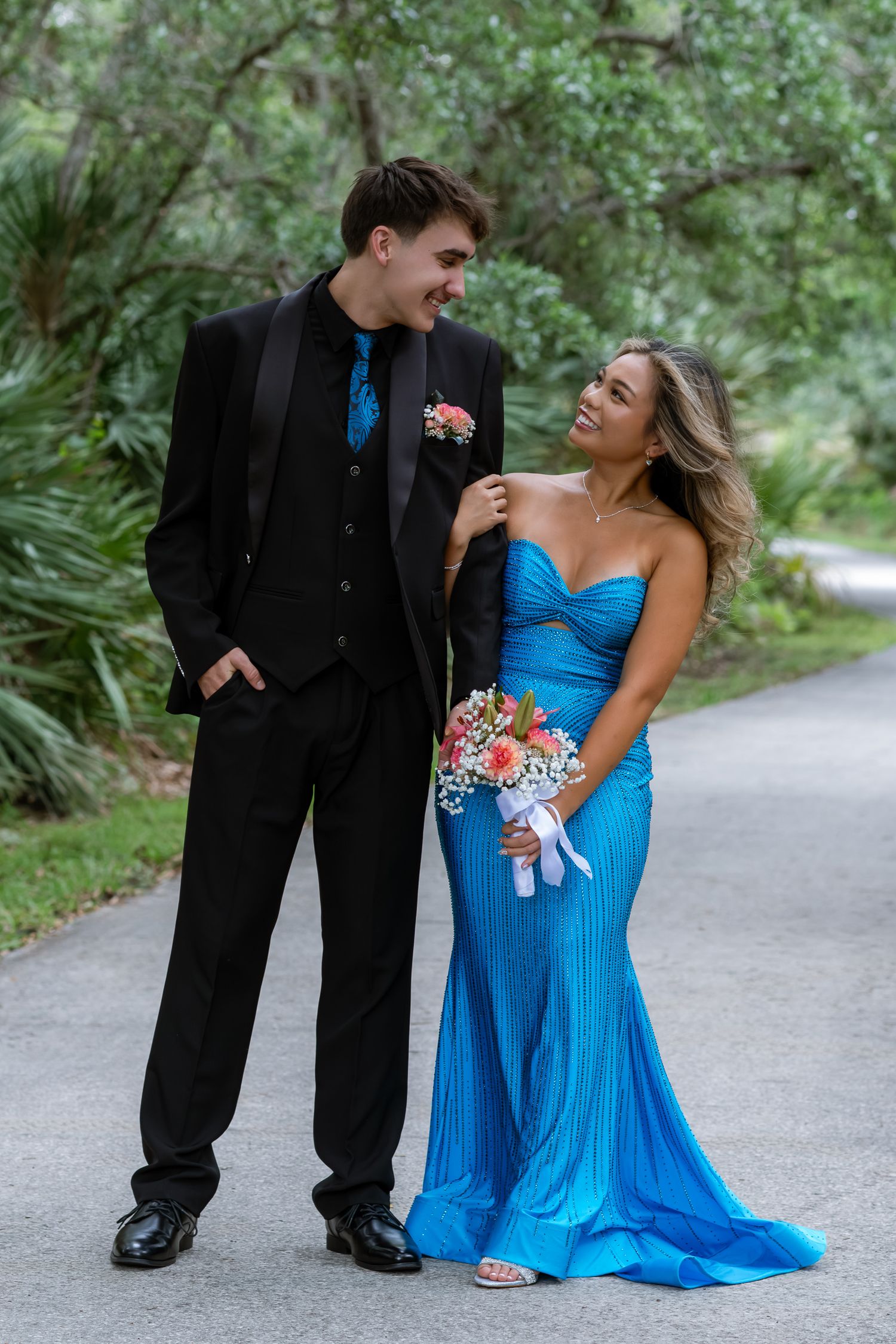 Young couple dressed formally posing together outdoors