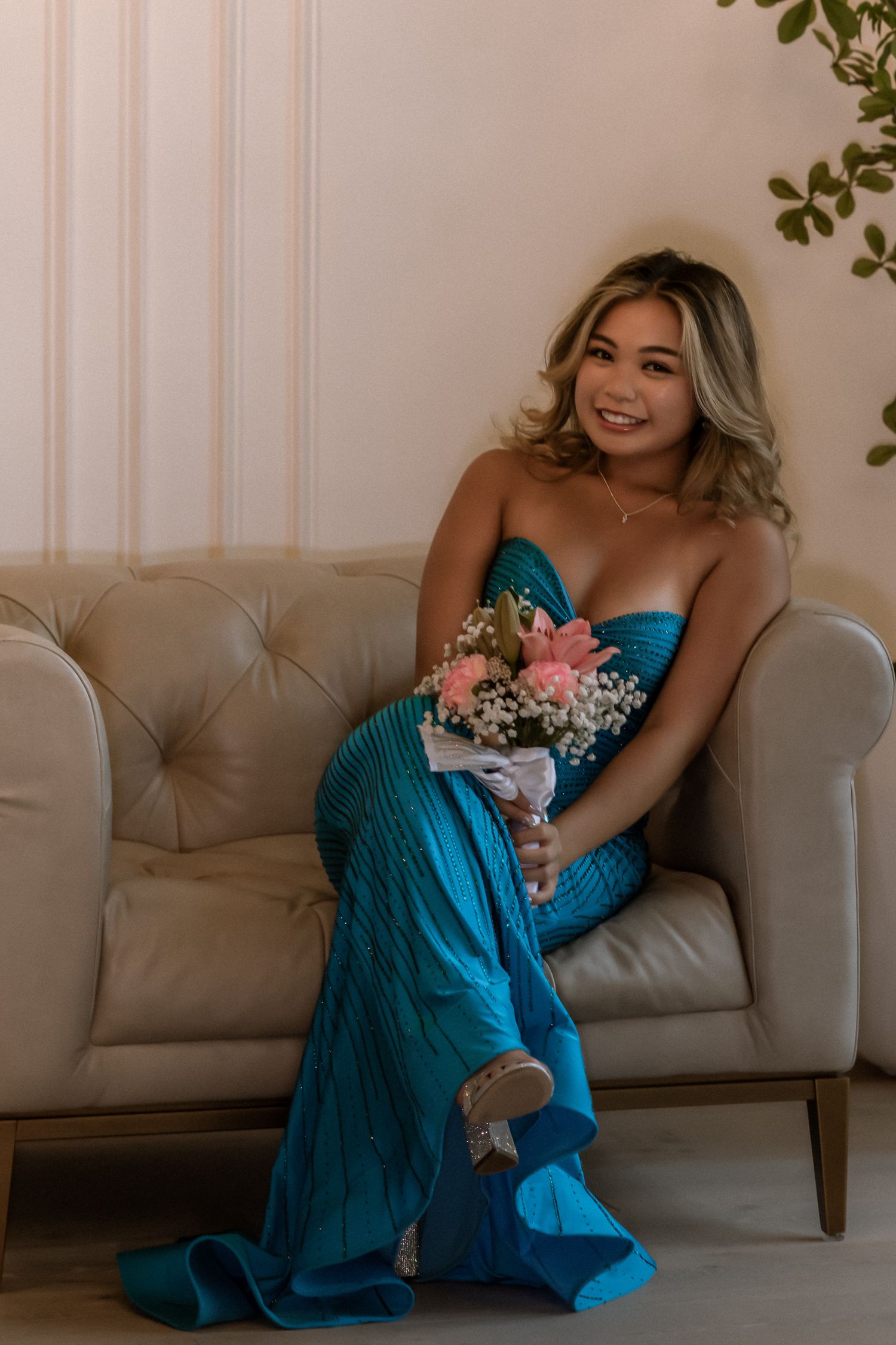 Seated portrait of a young woman in a blue formal dress