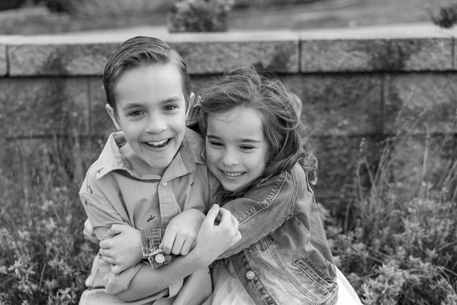 A series of five black and white photos showing sweet candid moments between two people embracing and laughing together.