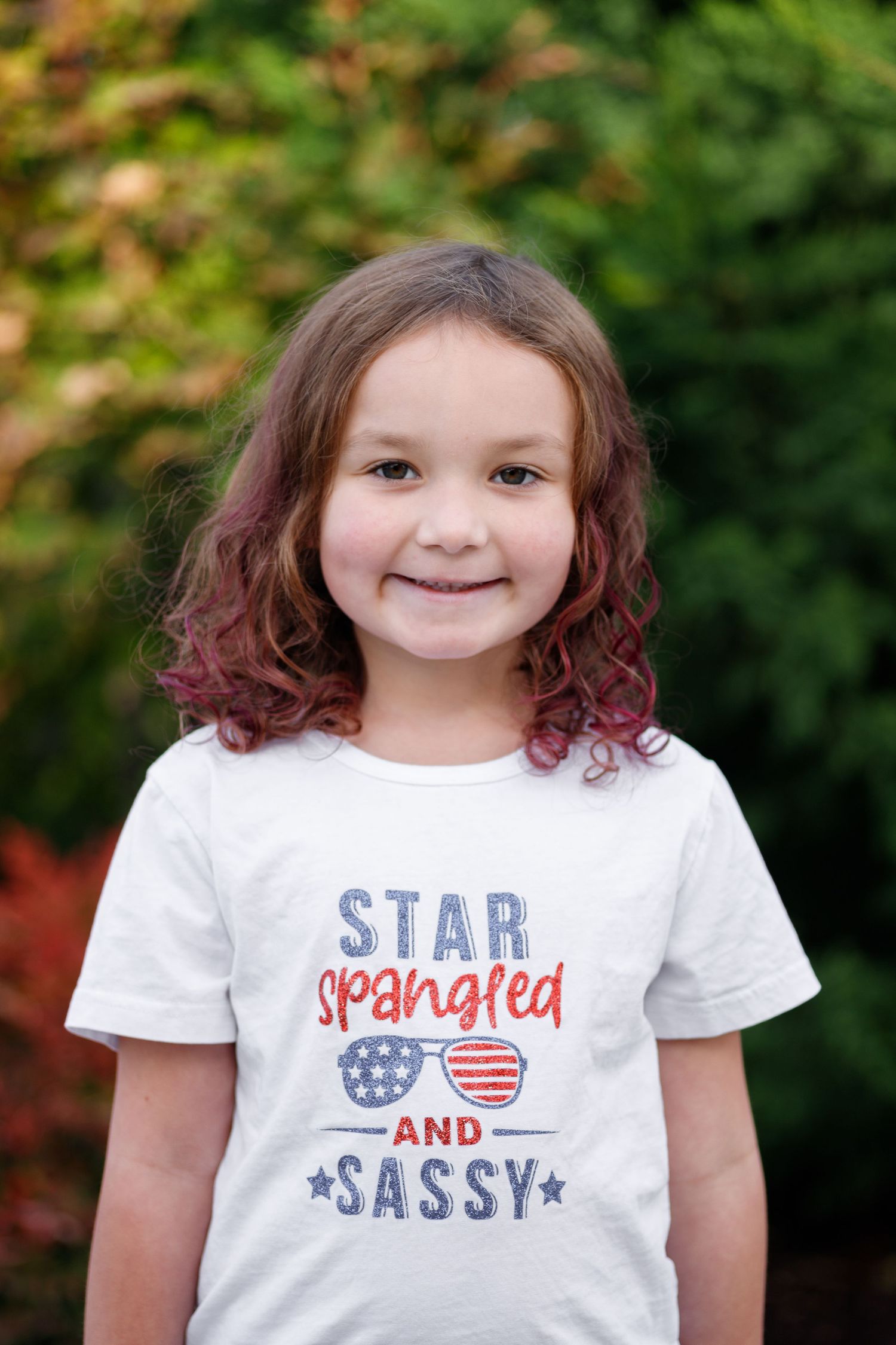 A series of photos showing a white patriotic t-shirt with 'Star and Sassy' text against a green outdoor background.