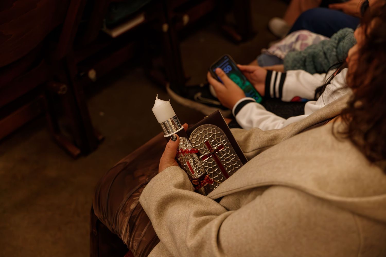 Someone holds a Harry Potter book while relaxing on a comfortable couch in dim lighting.