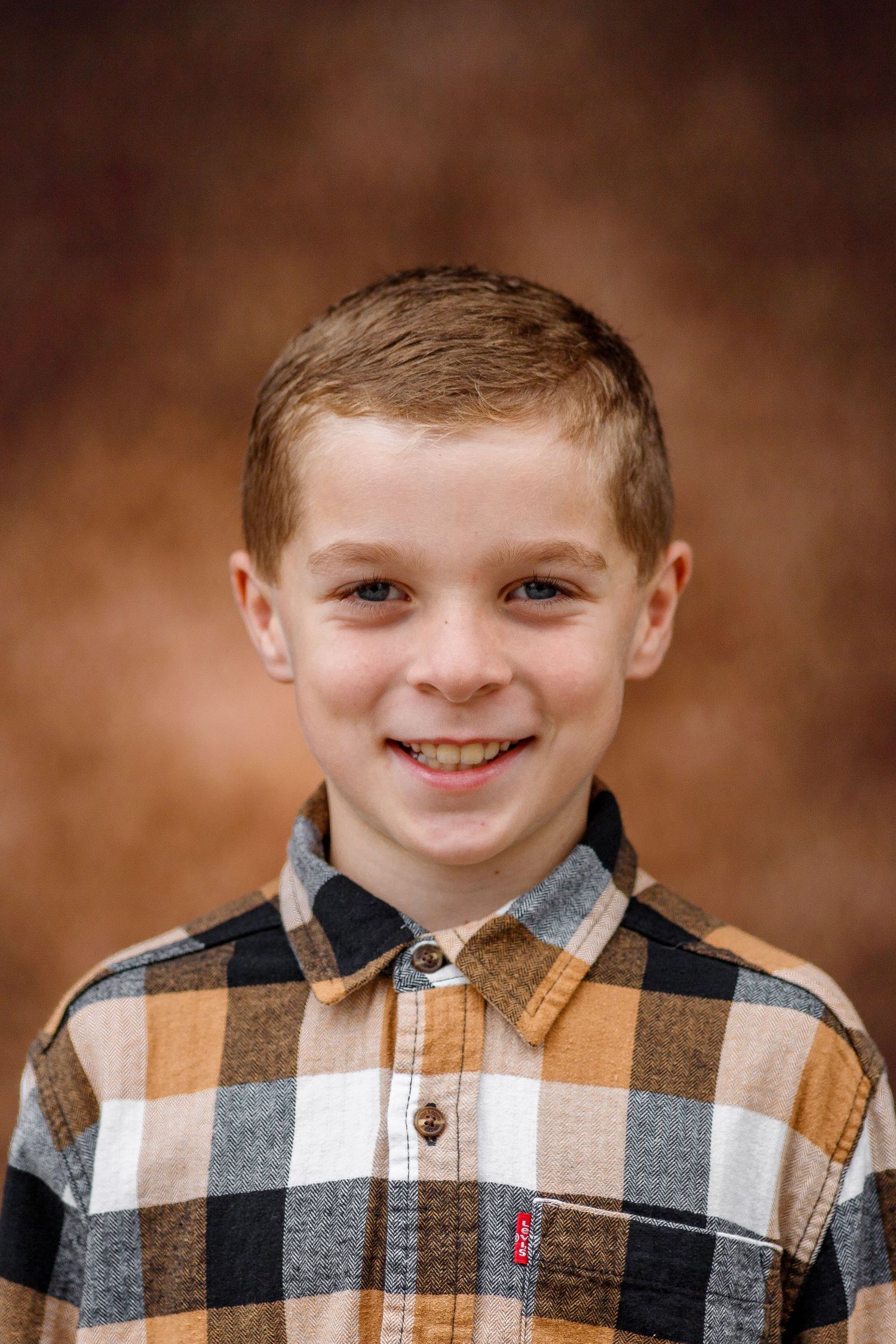 A series of cropped portraits showing a young boy wearing a brown and white plaid button-up shirt.