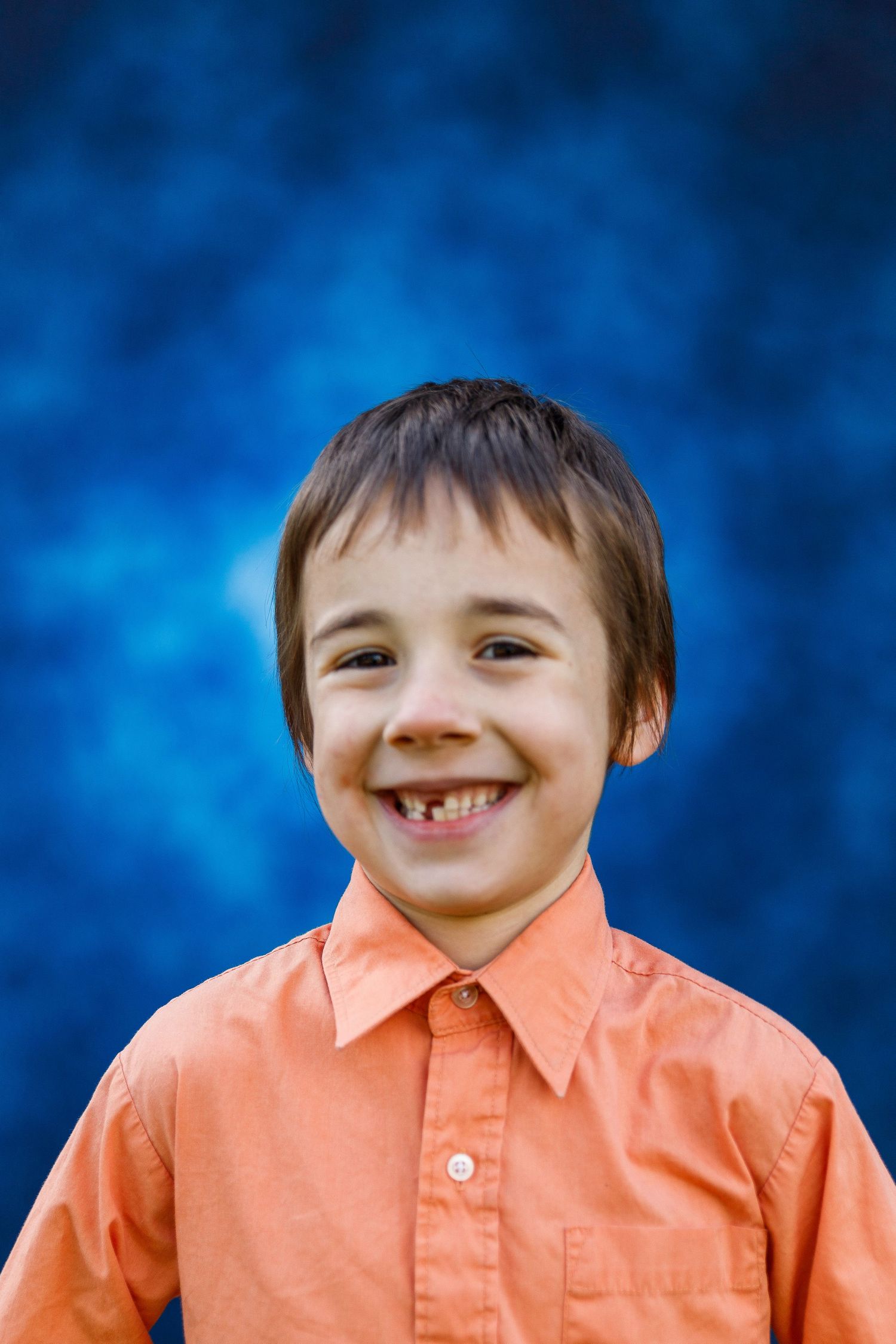 A sequence of images showing a young person in an orange button-up shirt with a joyful smile against a blue background.