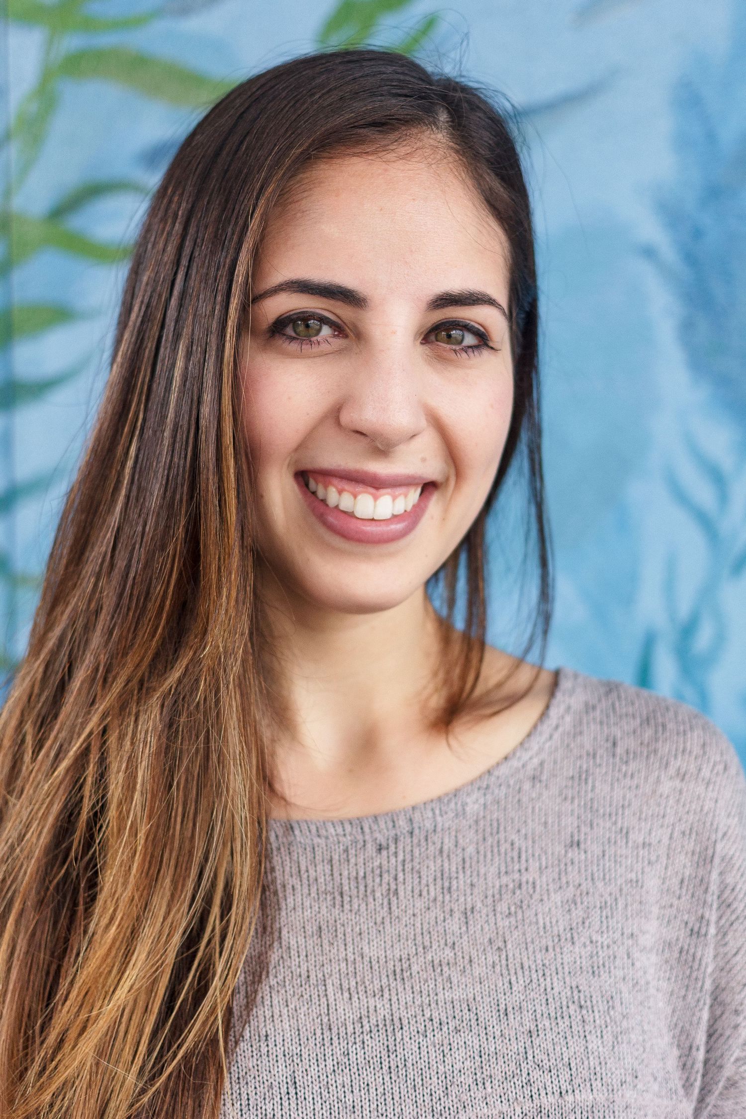 A series of headshots showing a bright smile and long brown hair against a blue background.