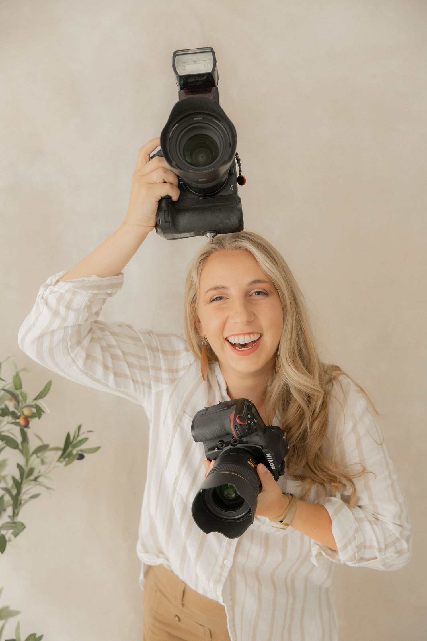 Professional photographer in white shirt holding camera in various creative poses against light background.