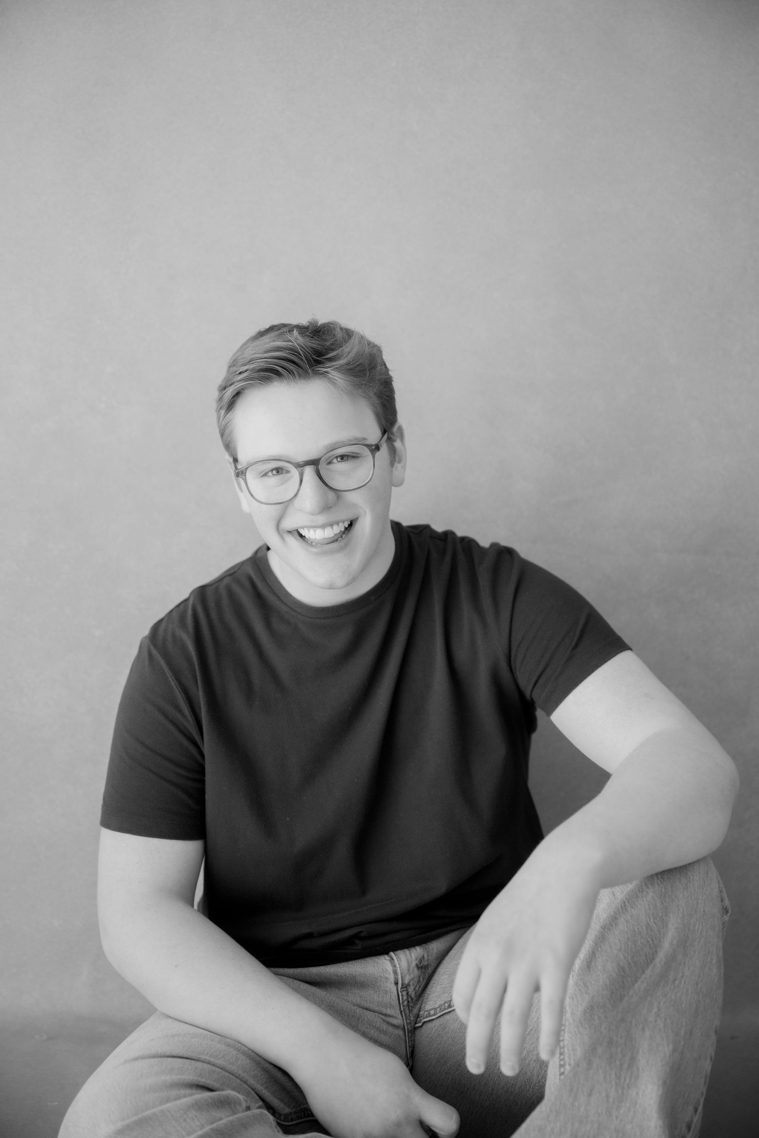 Black and white portrait series showing candid expressions and poses in a minimalist studio setting.