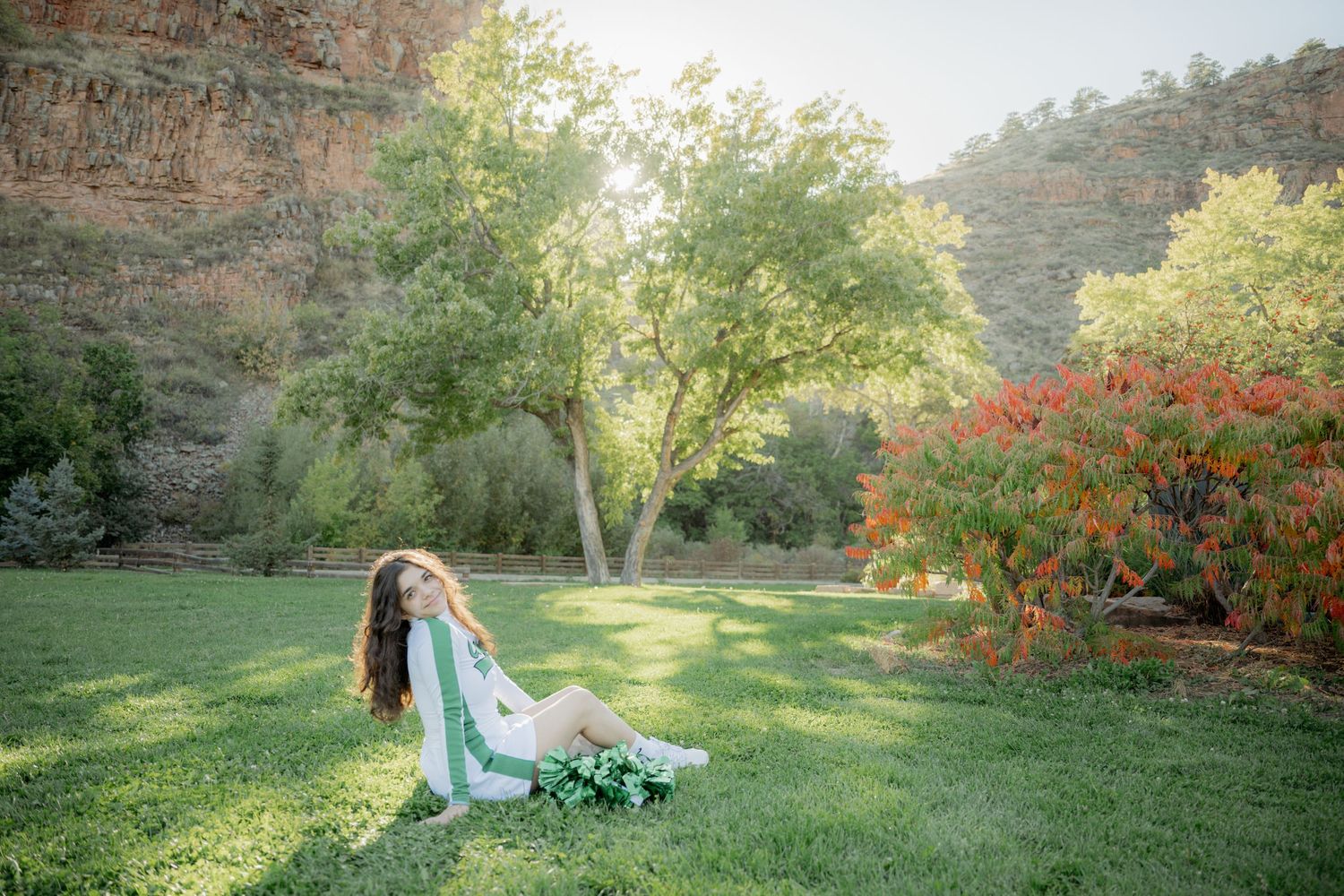 A serene garden wedding ceremony setup with white chairs and floral arrangements on a lush green lawn.