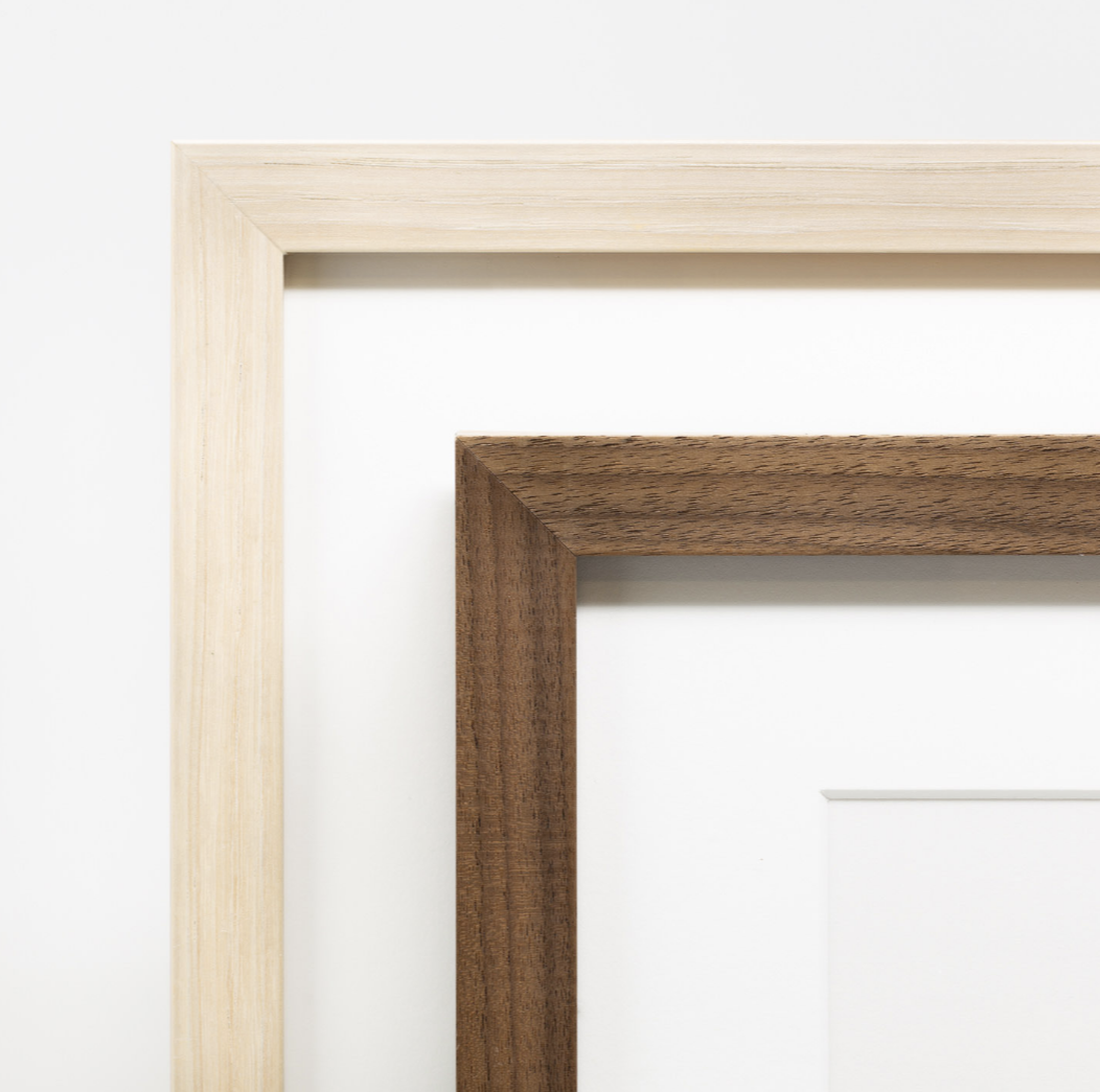 Close-up view of a wooden picture frame corner joint showing detailed craftsmanship and natural wood grain texture.