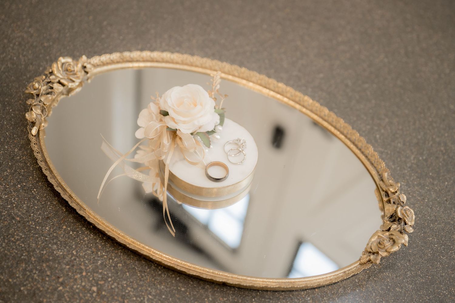 A vintage gold-framed mirror with ornate details reflects soft light in an elegant display.