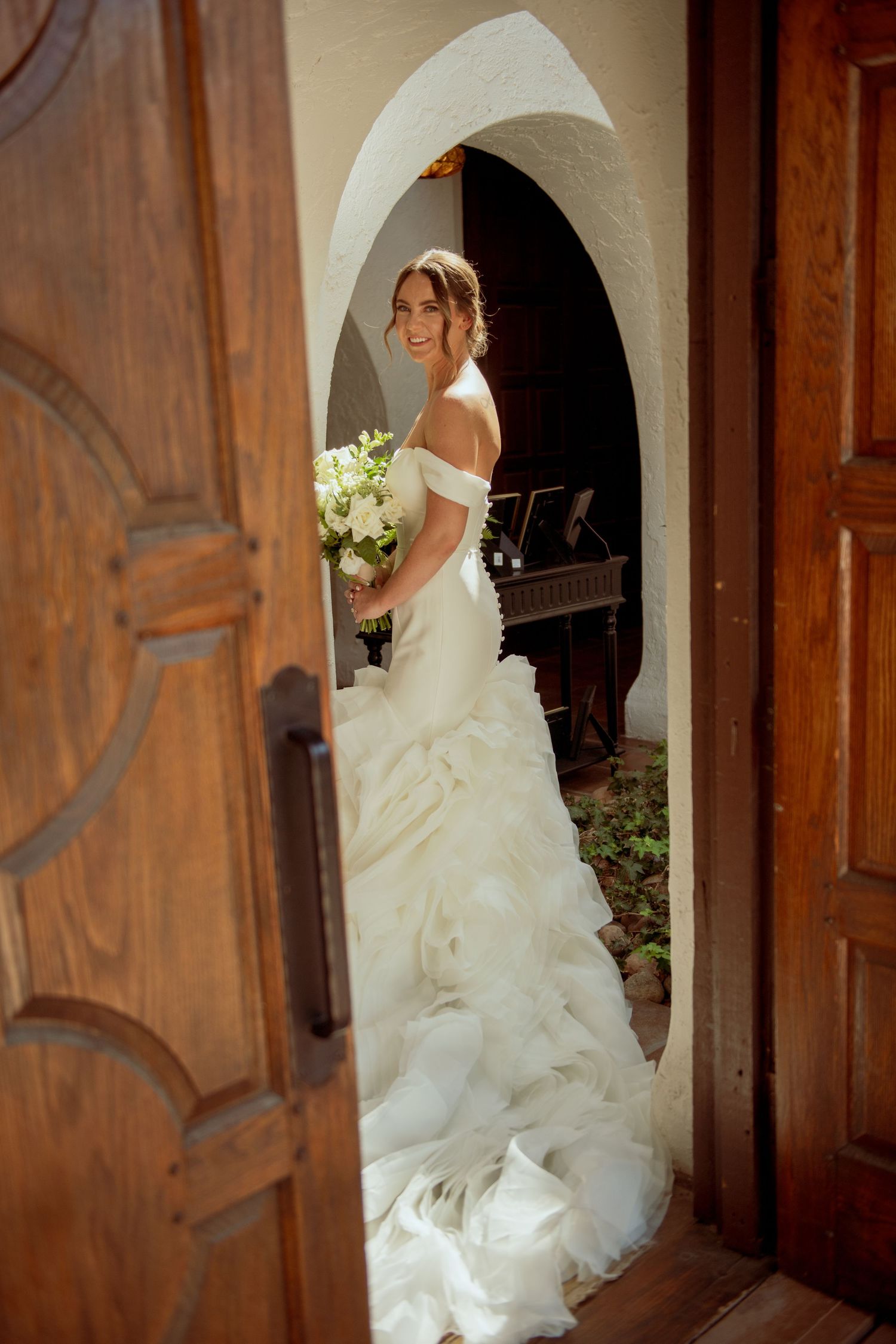 Bride in flowing white wedding gown ascends wooden staircase in a series of sequential photos showing graceful movement.