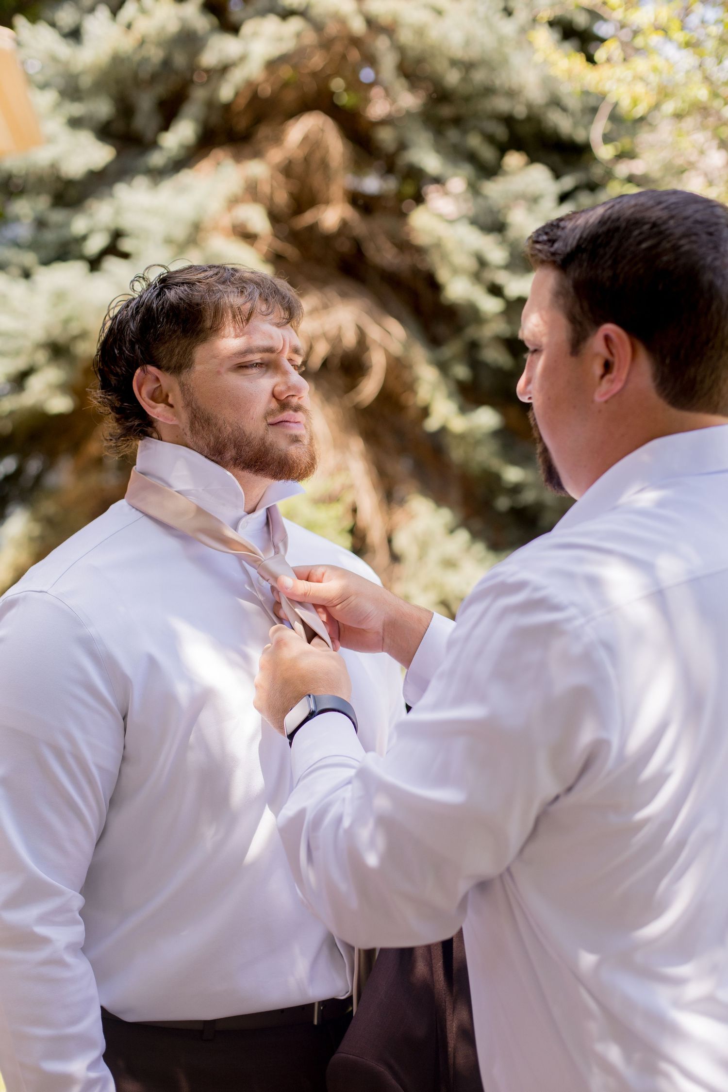 Two people in white shirts engage in a physical altercation sequence shown in multiple frames outdoors.