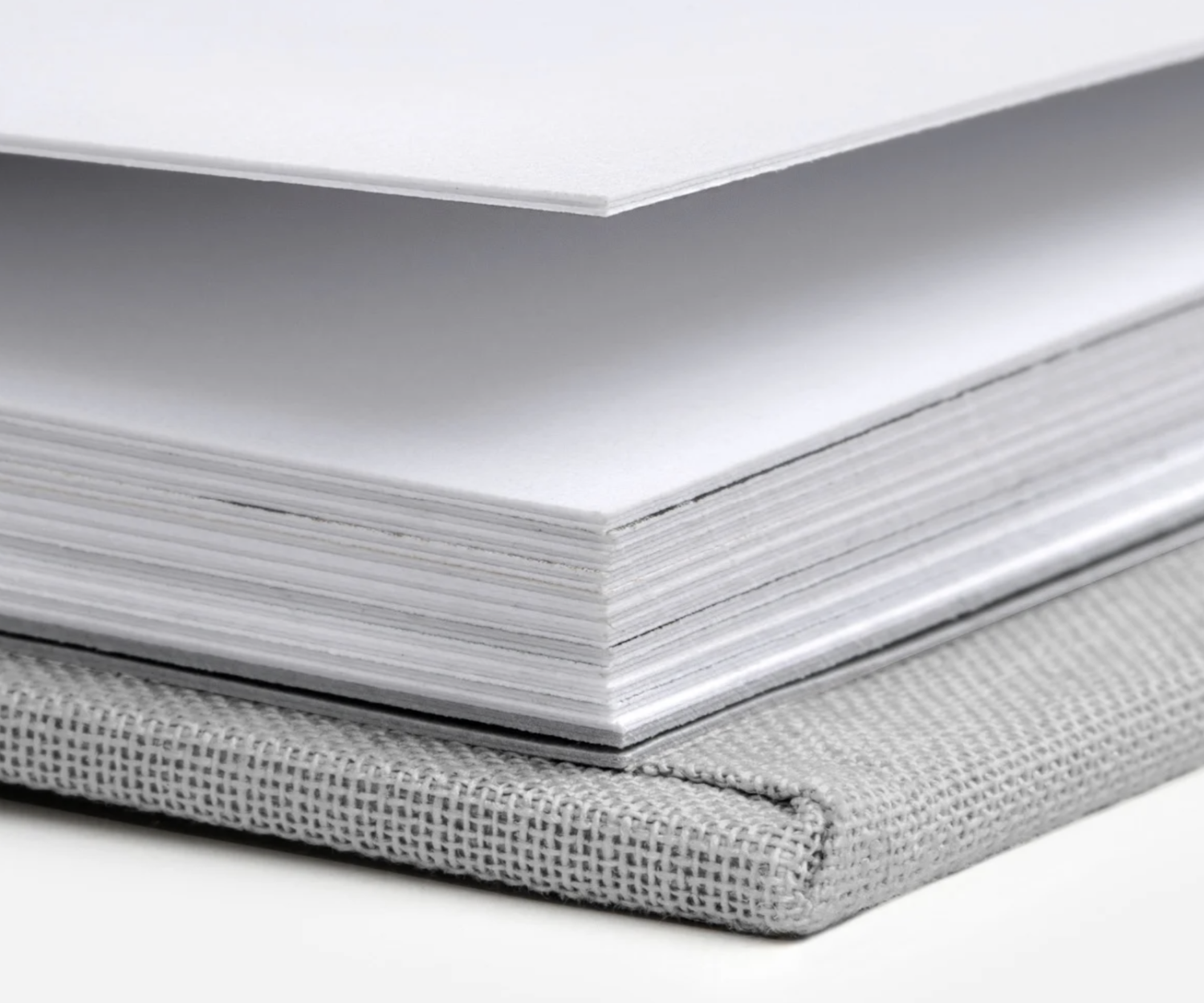 White paper stacks with different edge views showing layered sheets and textured binding materials.