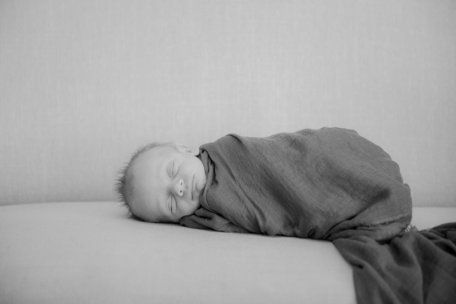 A series of black and white photographs showing someone sleeping in various positions on a bed.