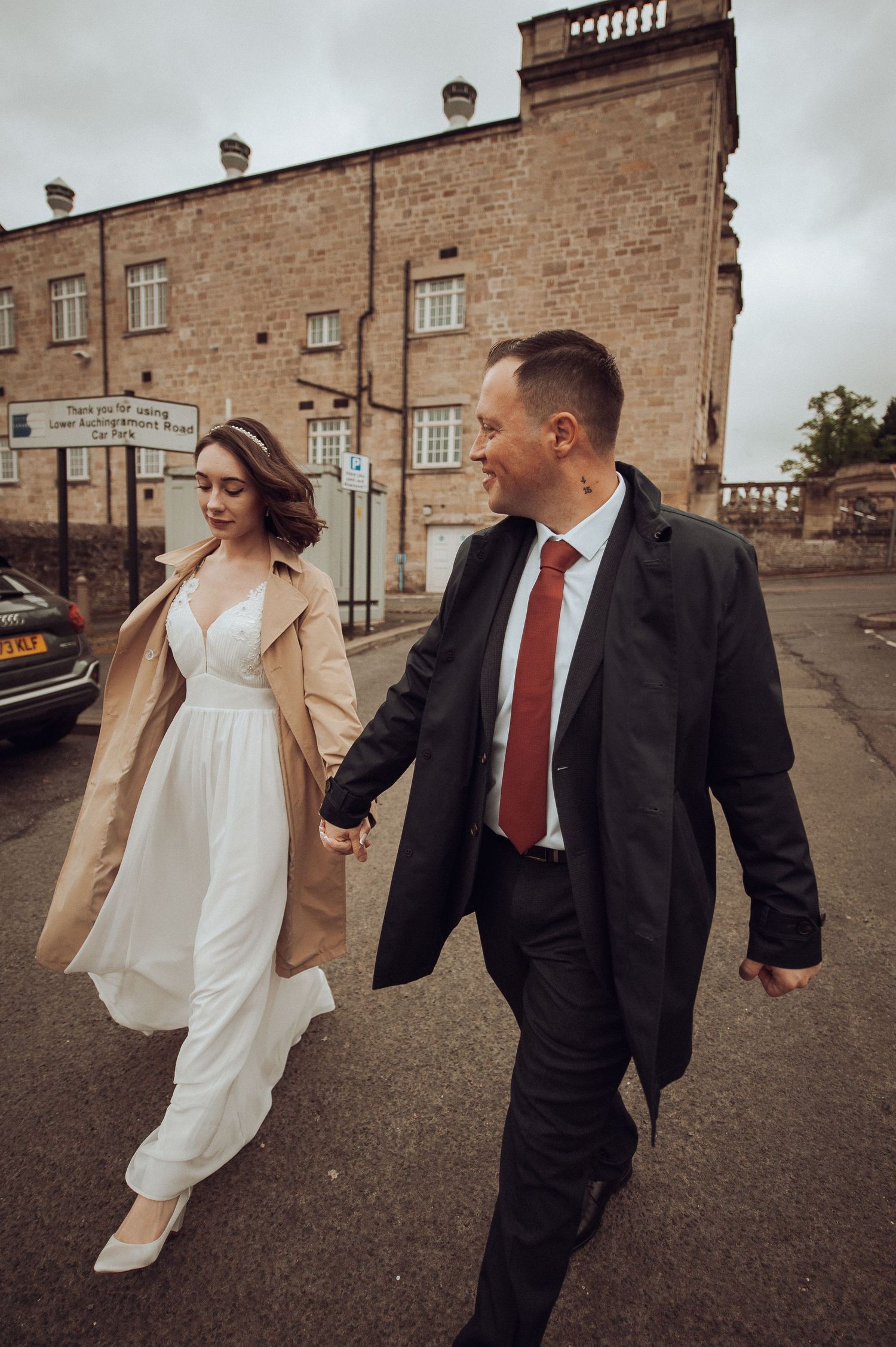 Newlyweds walking hand in hand through a sunlit garden