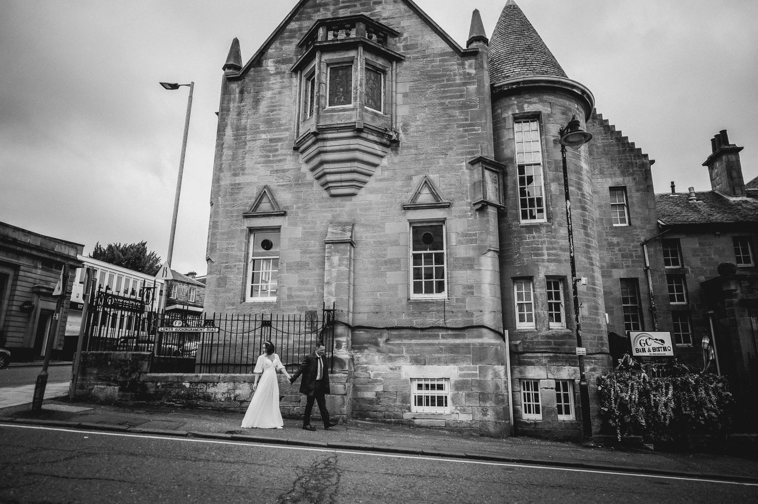 Newlyweds walking hand in hand through a sunlit garden