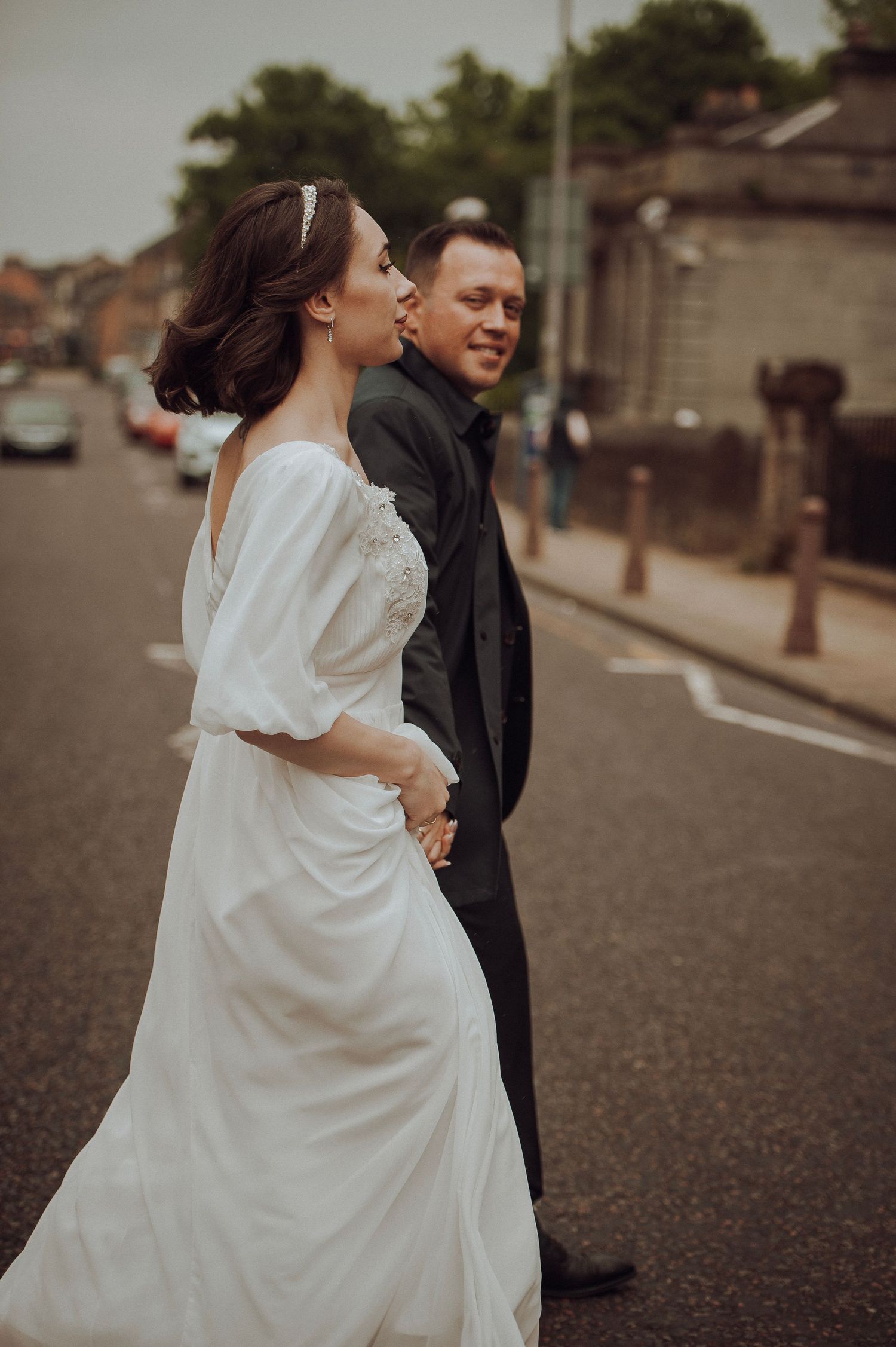 Newlyweds walking hand in hand through a sunlit garden