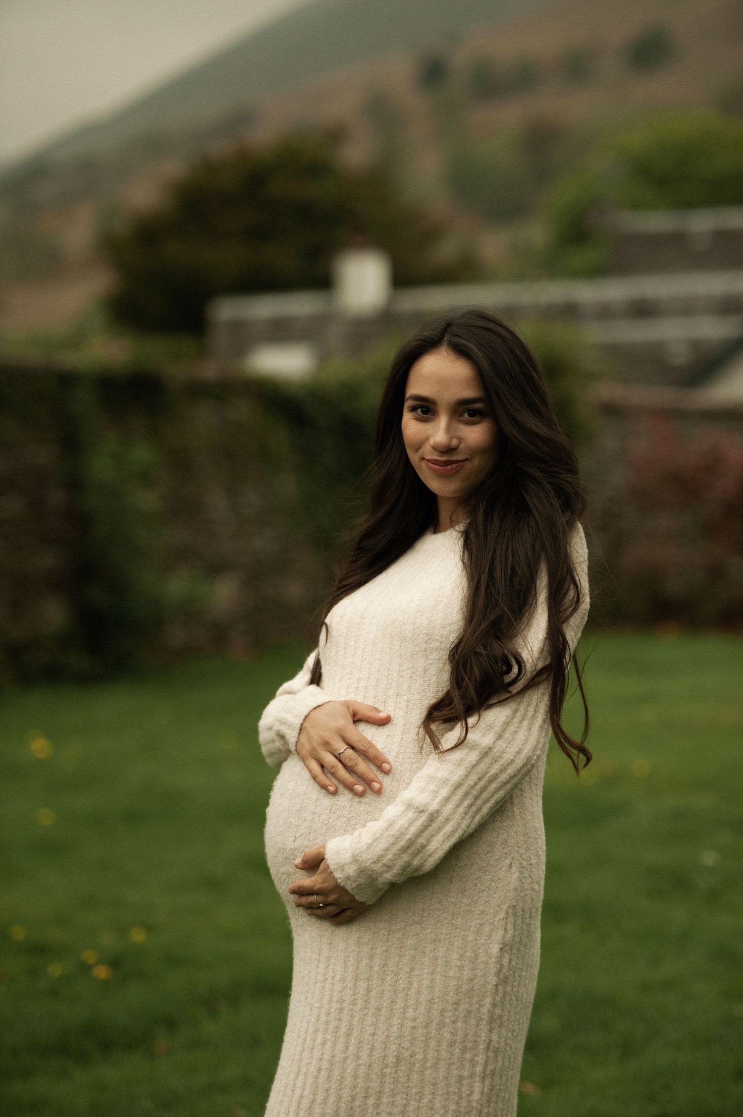 Little one gently touching mom’s pregnant belly in soft light
