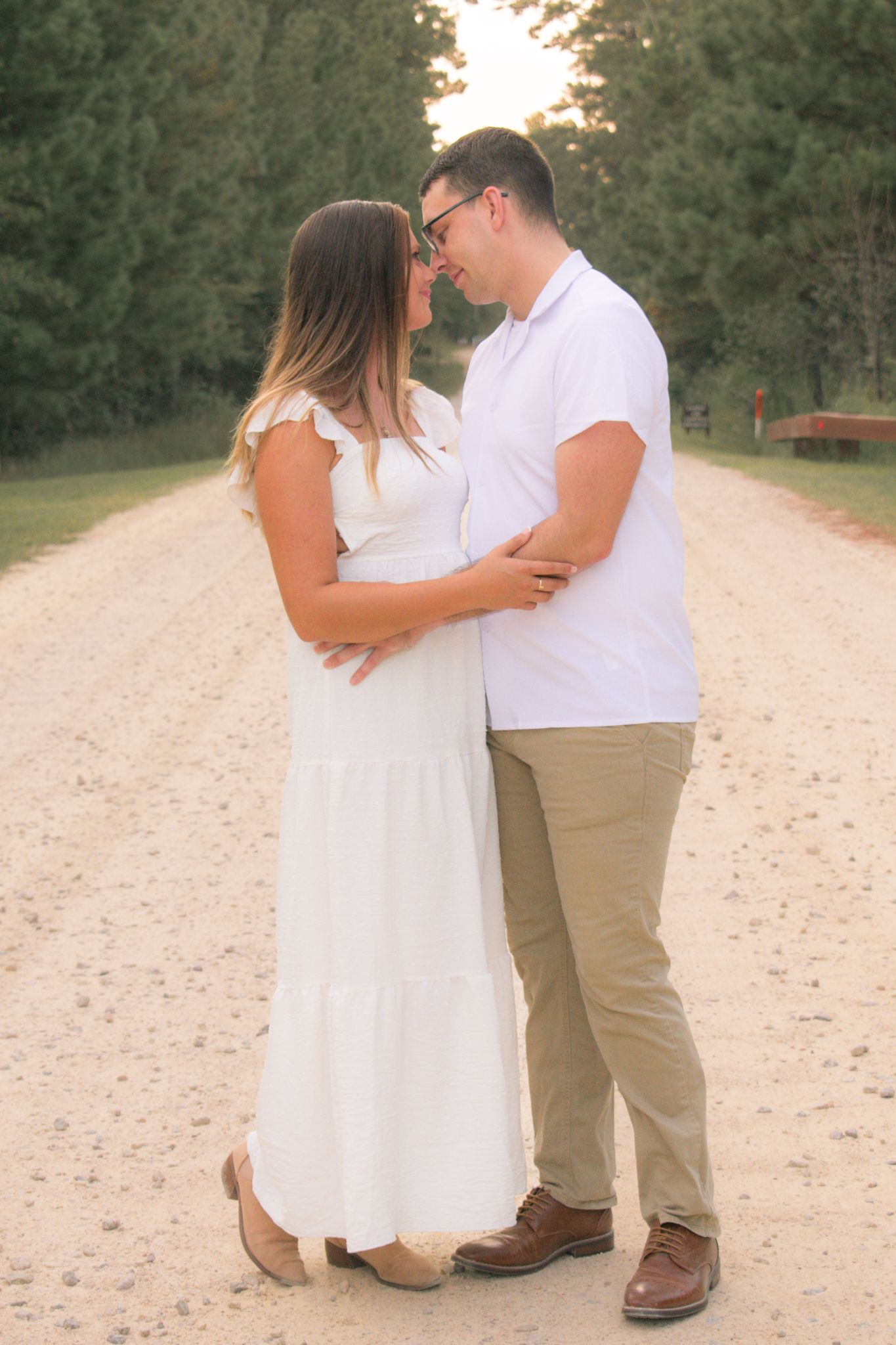 Engagement session on sandy path during golden hour sunset.