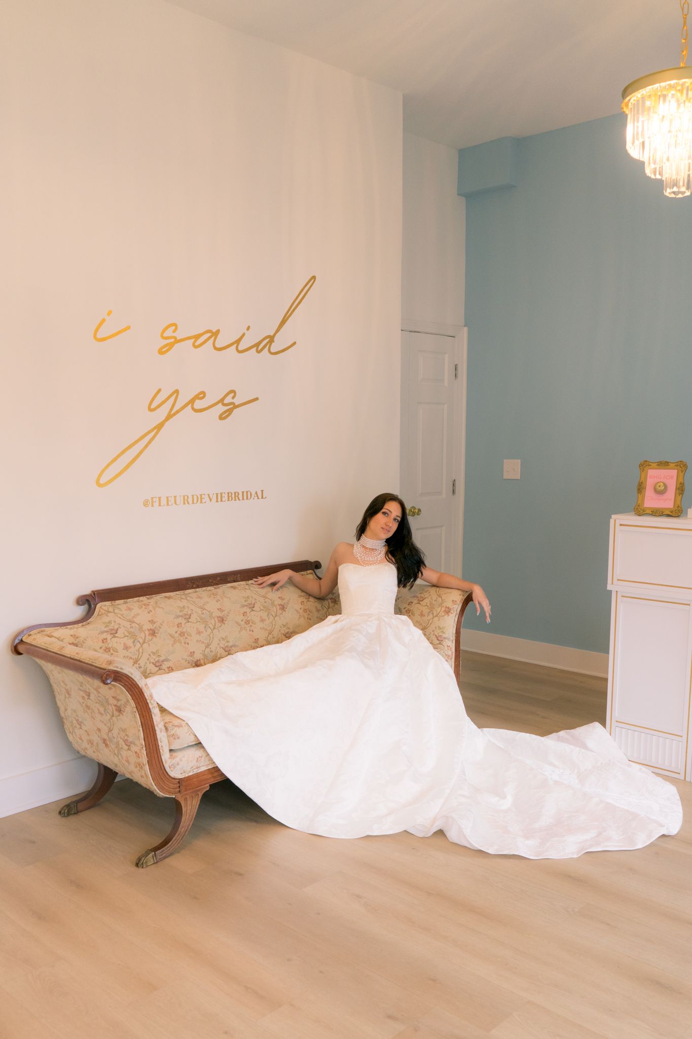A series of four photos showing a white wedding dress flowing across an antique chaise lounge against light blue walls.