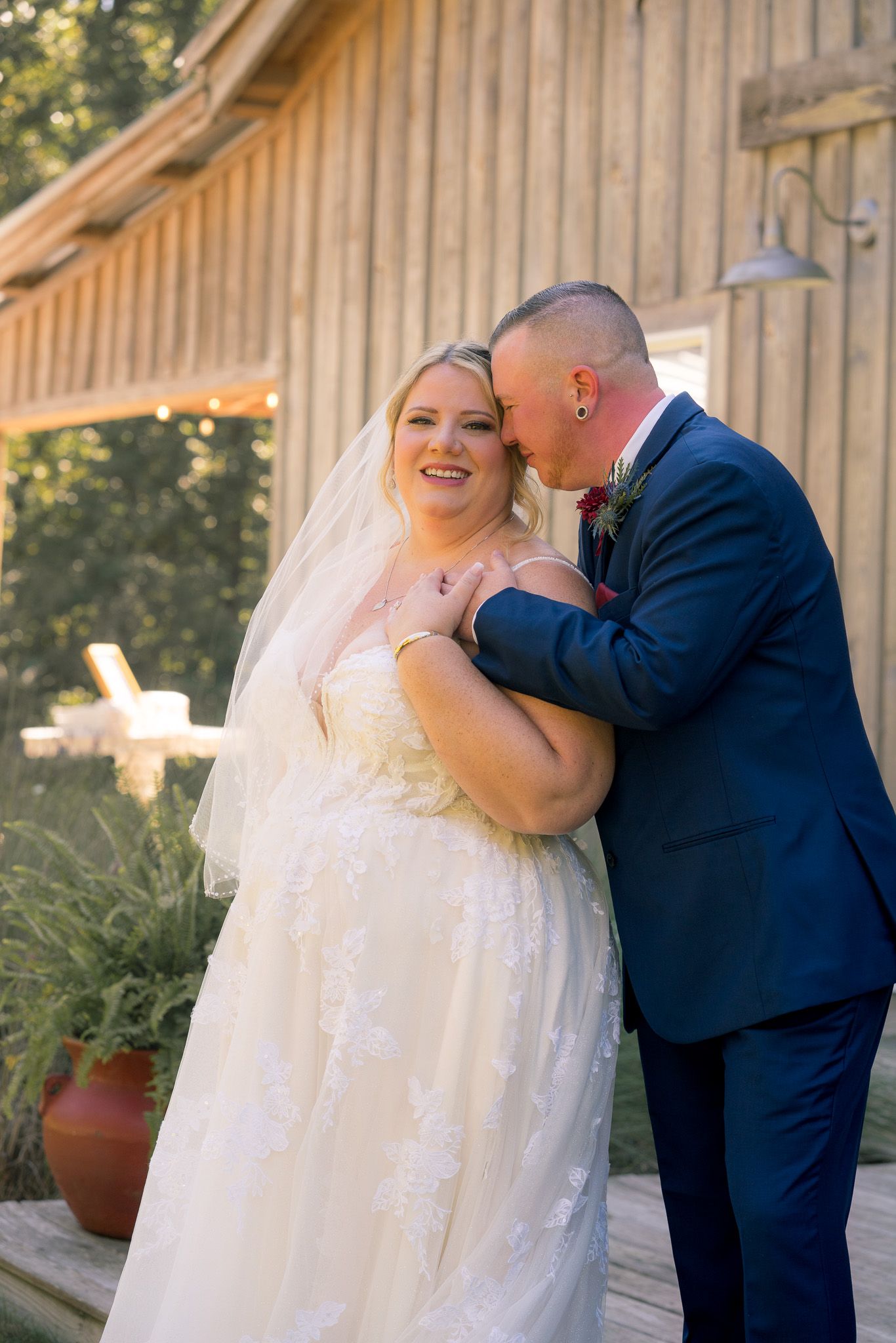 A romantic first look sequence between a bride in a white dress and groom in a navy suit at a rustic barn venue.