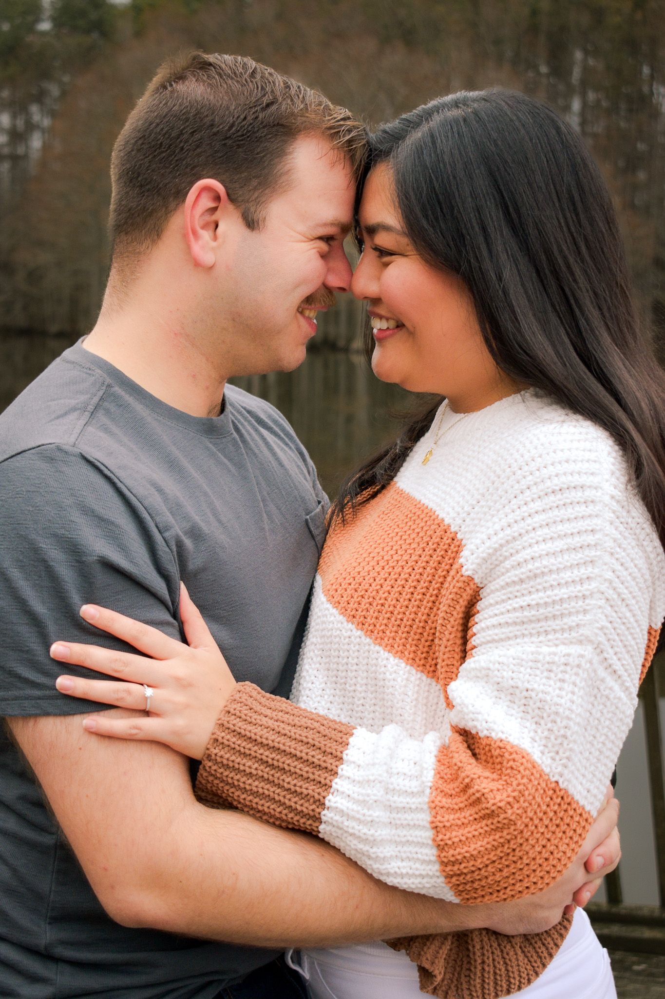 Couple in cozy sweaters sharing intimate moments against natural backdrop.