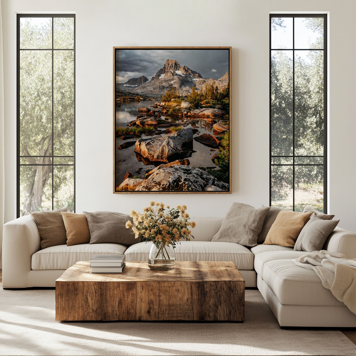 Modern living room with white sectional sofa, wooden coffee table, and landscape artwork displayed on beige walls.