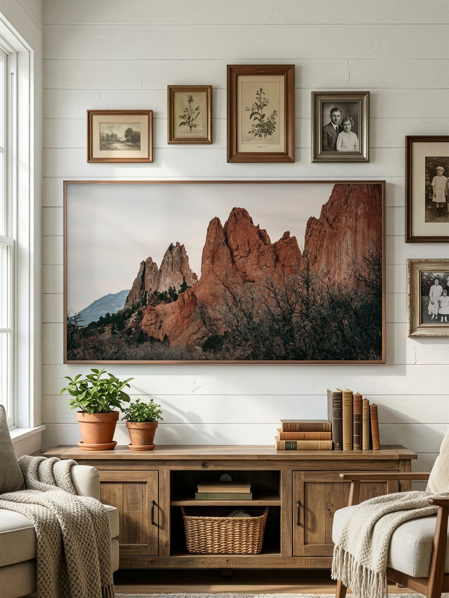 Panoramic landscape photographs of red rock formations hang above a modern wood console in a cozy living room setting.