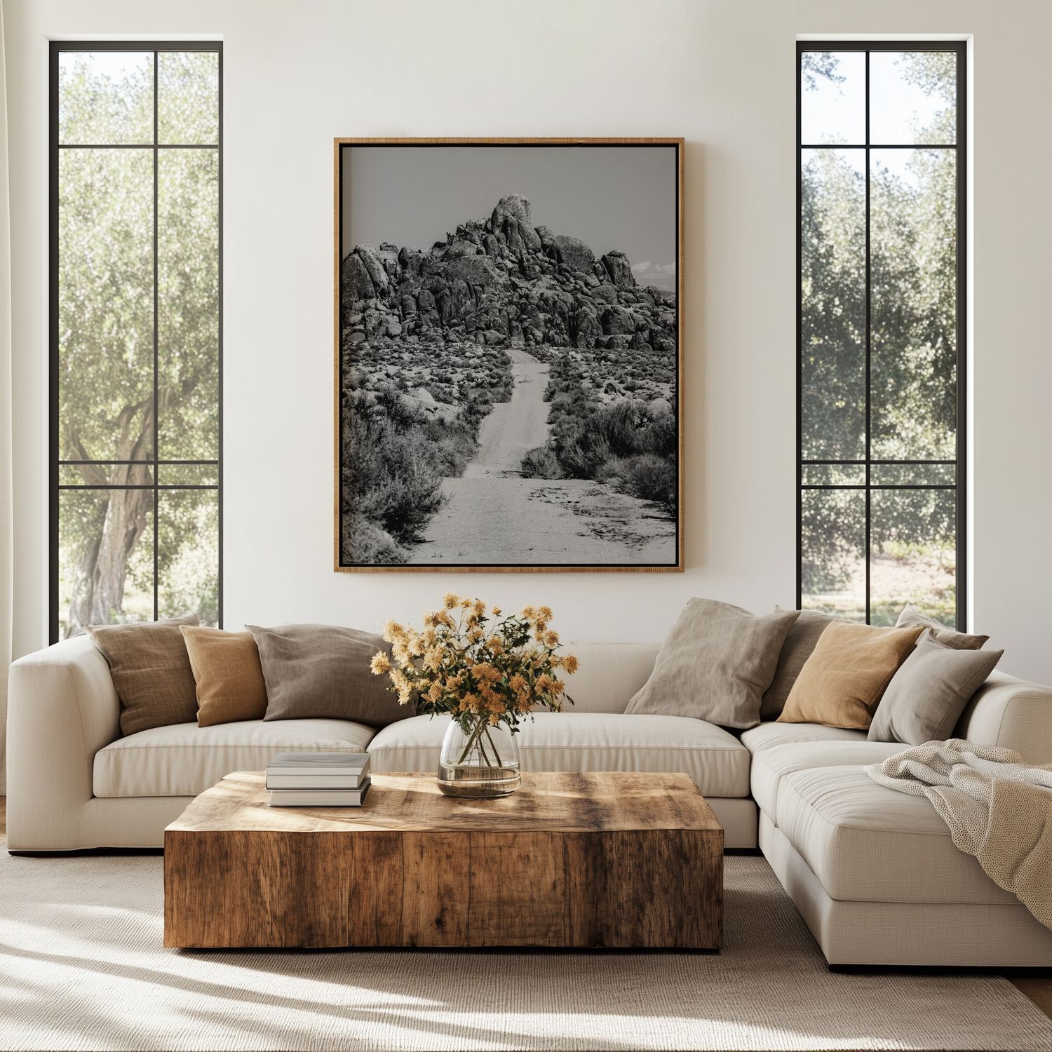 Contemporary living space featuring white sectional, wooden table and black and white mountain photography on walls.