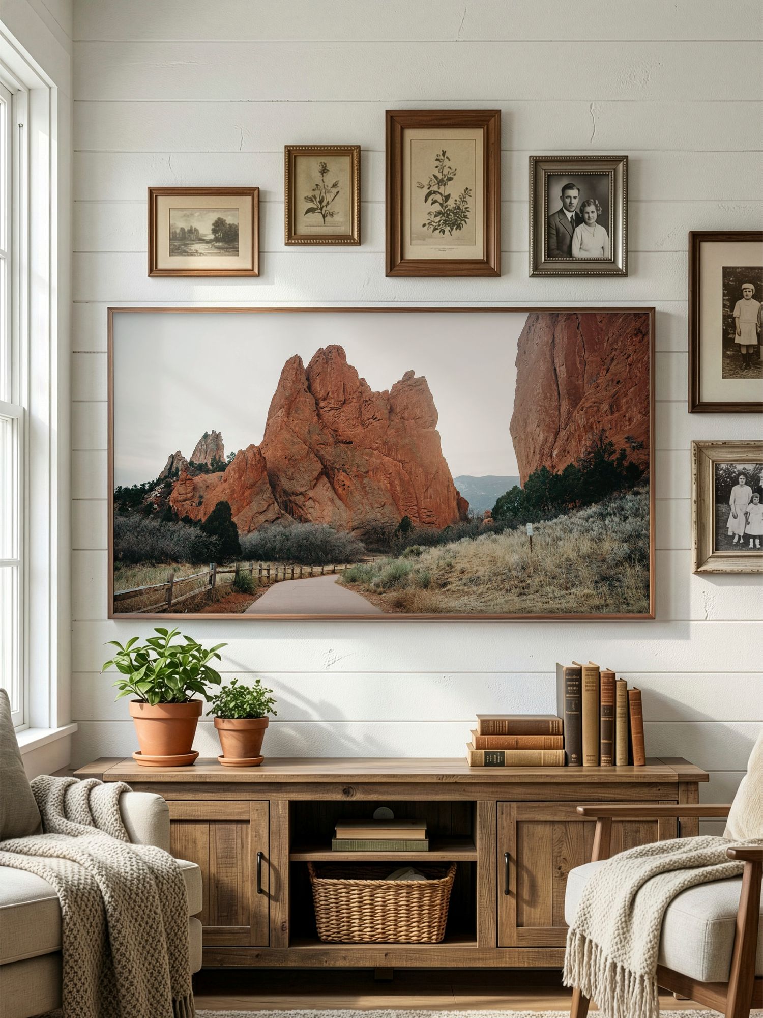 A modern living room features desert landscape panoramic artwork, white shiplap walls, and earth-toned furnishings.