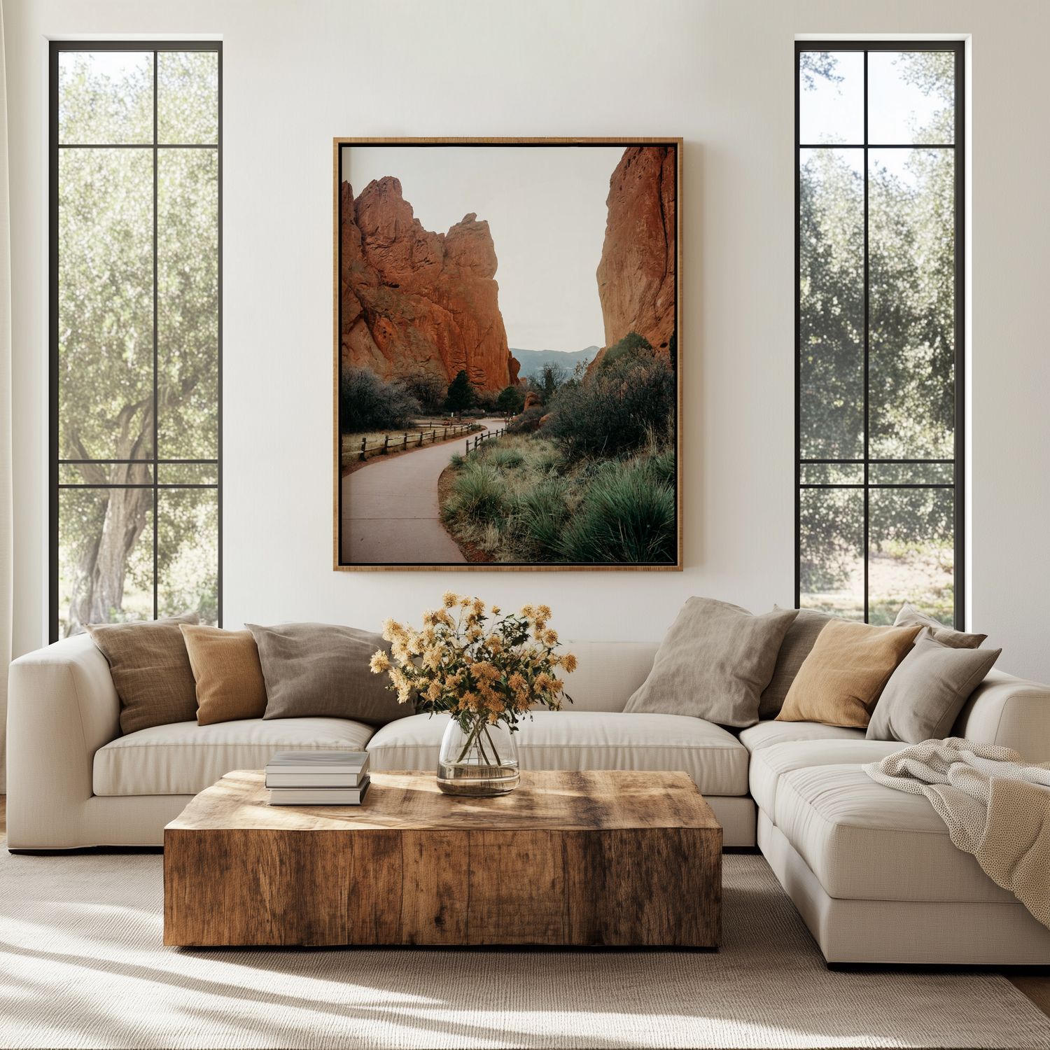 Modern living room with cream sectional sofa, rustic wood coffee table, and desert landscape artwork in earth tones.