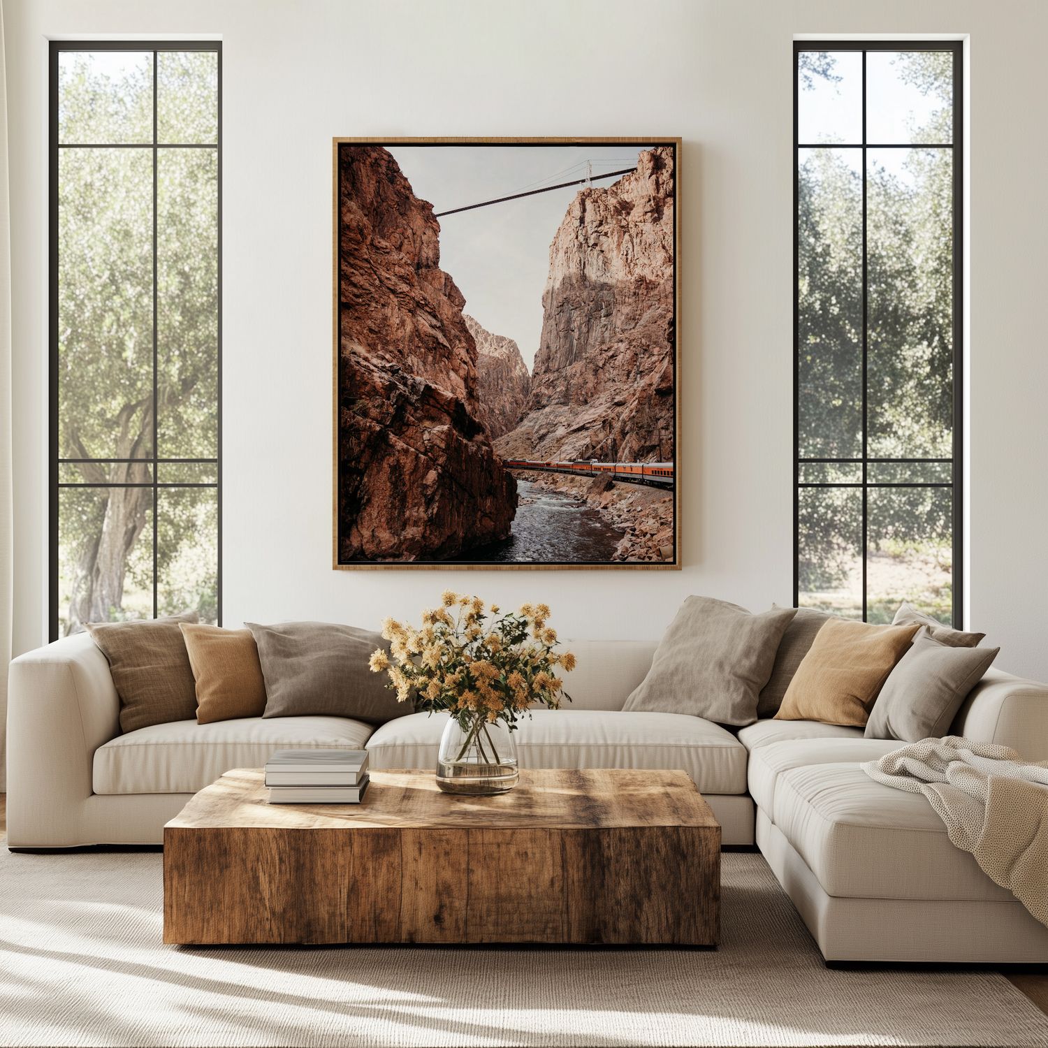 Modern living room with sectional sofa, rustic wood coffee table, and landscape photographs on white walls by windows.