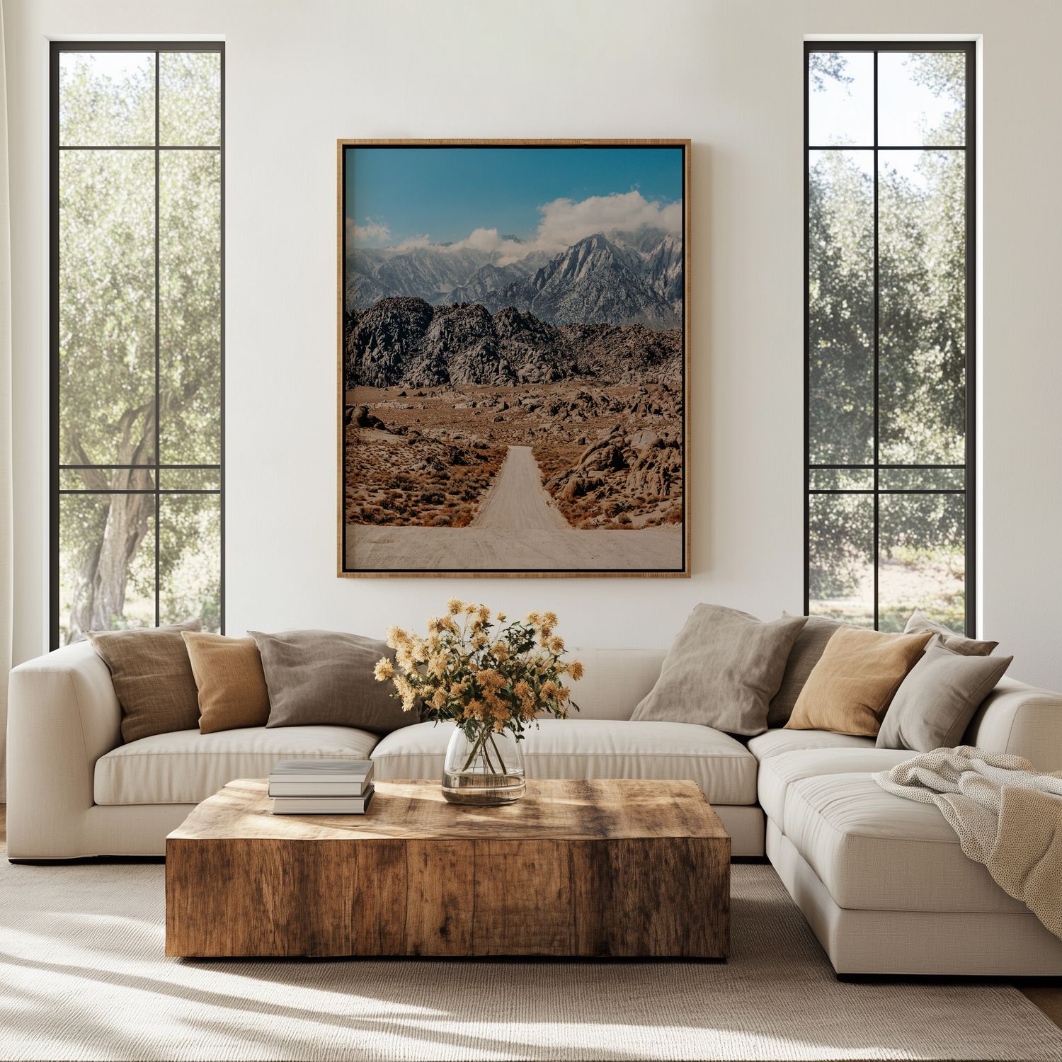 Modern living room with white sectional sofa, rustic wood coffee table, and desert landscape artwork on cream walls.