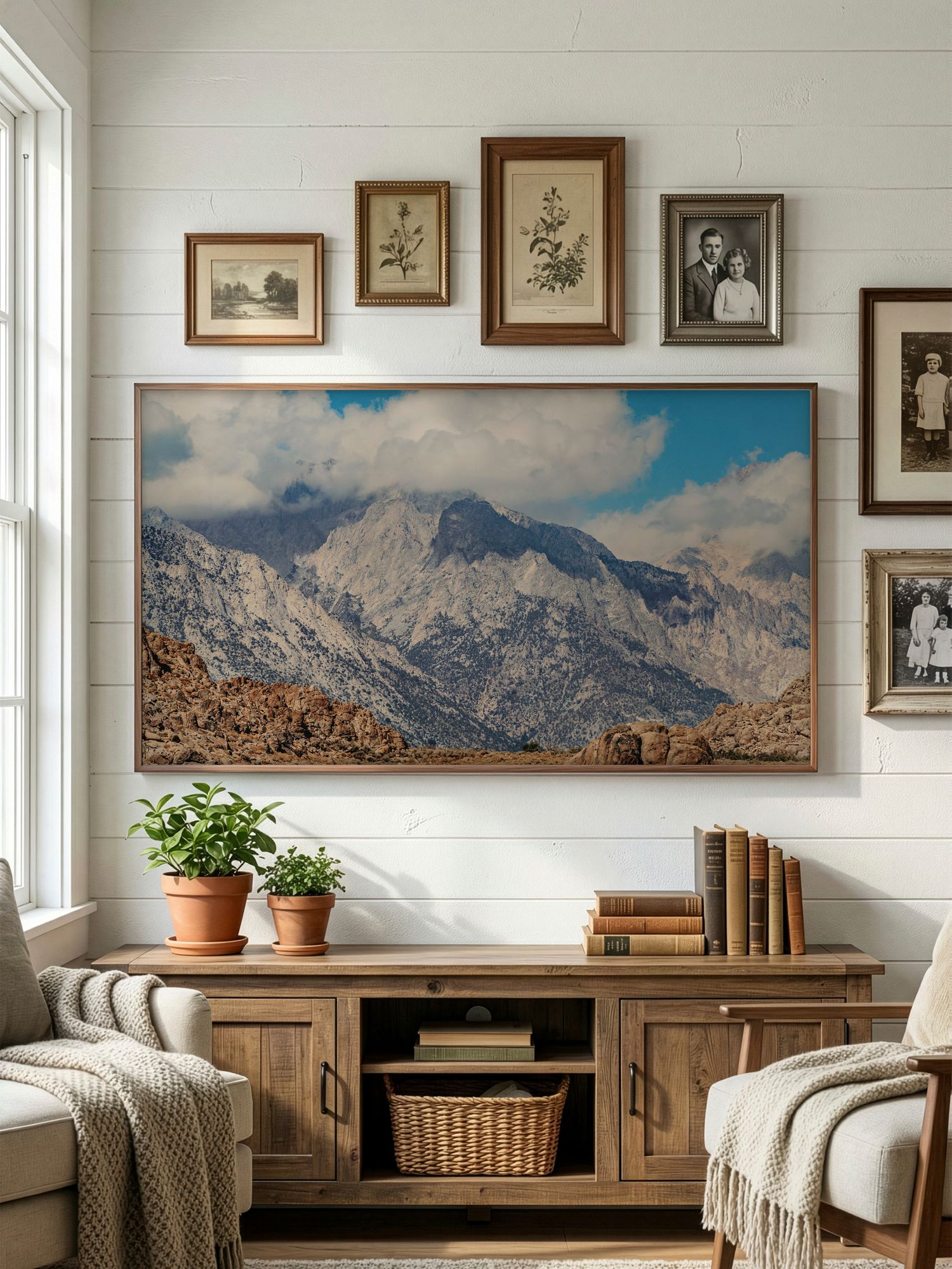 Panoramic mountain landscape artwork displayed on white walls above wooden furniture in a cozy living room setting.
