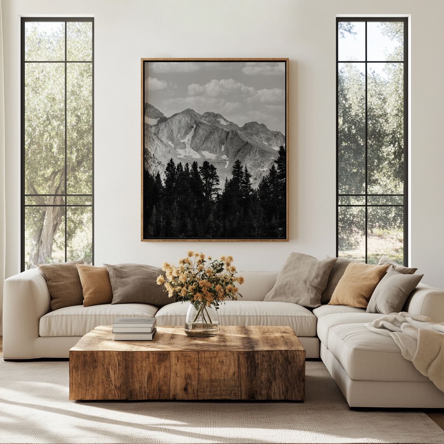 Modern living room with mountain artwork, white sectional sofa, and large windows bringing in natural light.