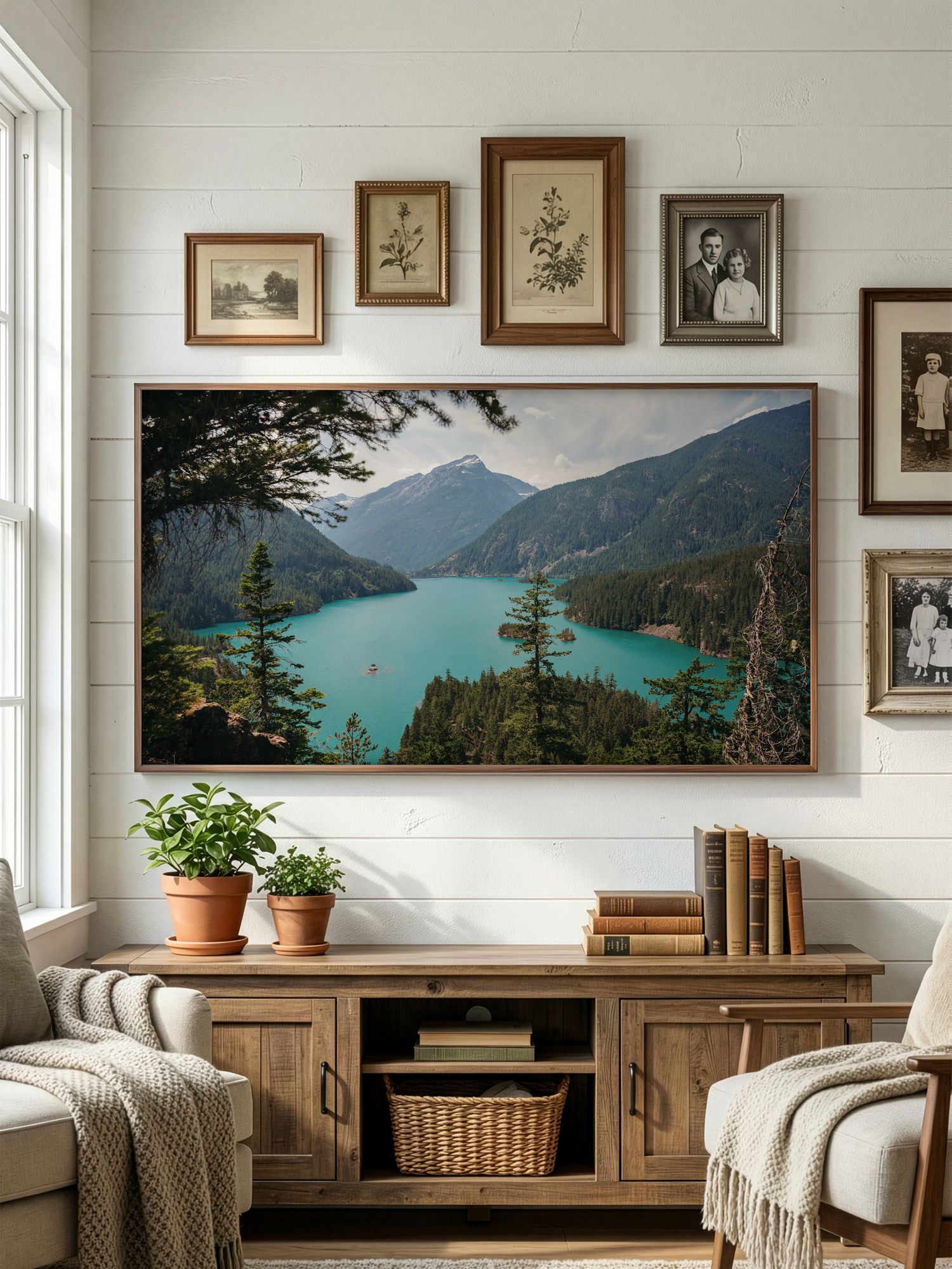 A cozy living room with panoramic mountain lake photography displayed on white walls above wooden furniture.