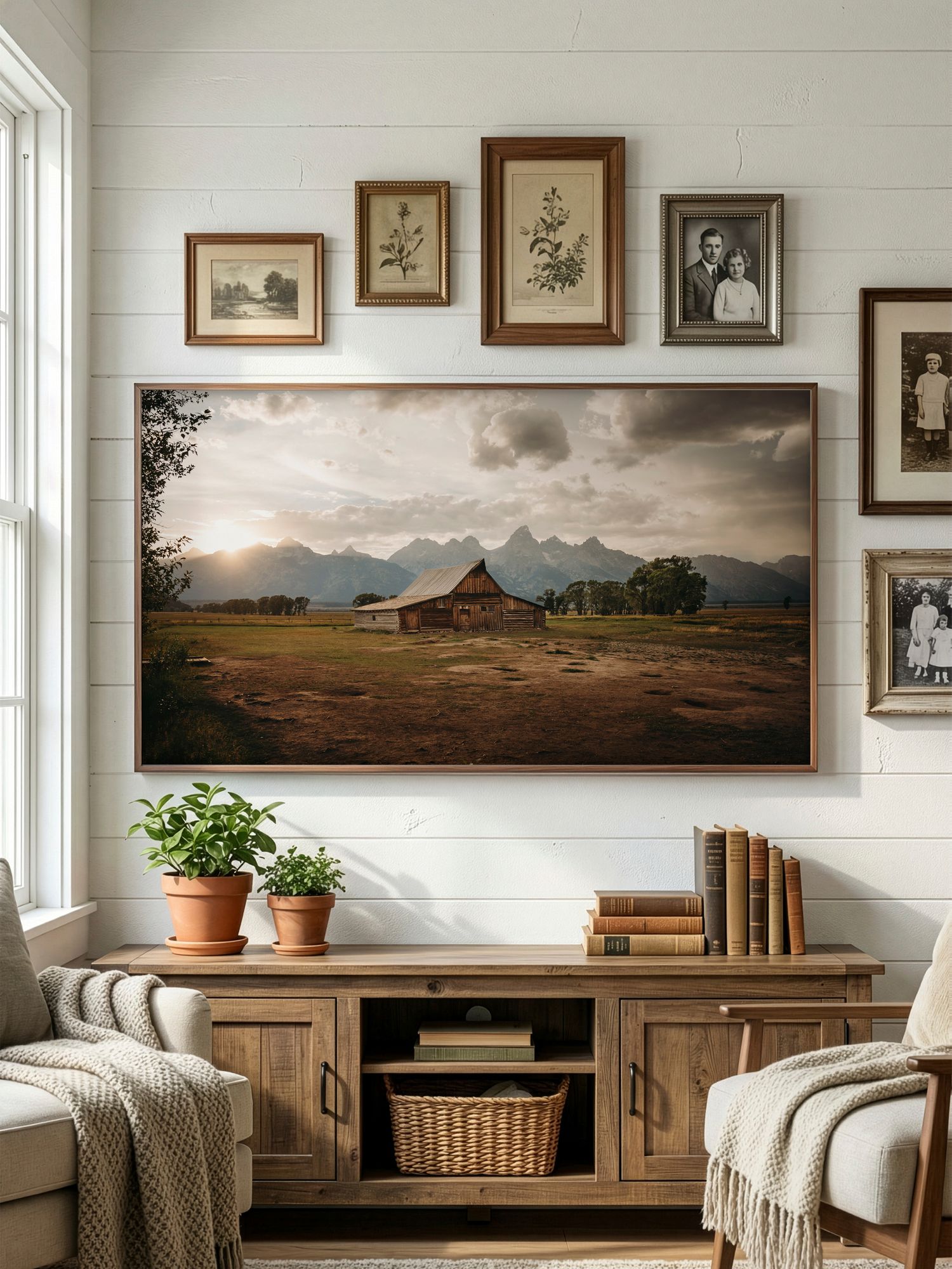 Rustic living room with panoramic landscape artwork, vintage frames, and cozy seating against white shiplap walls.