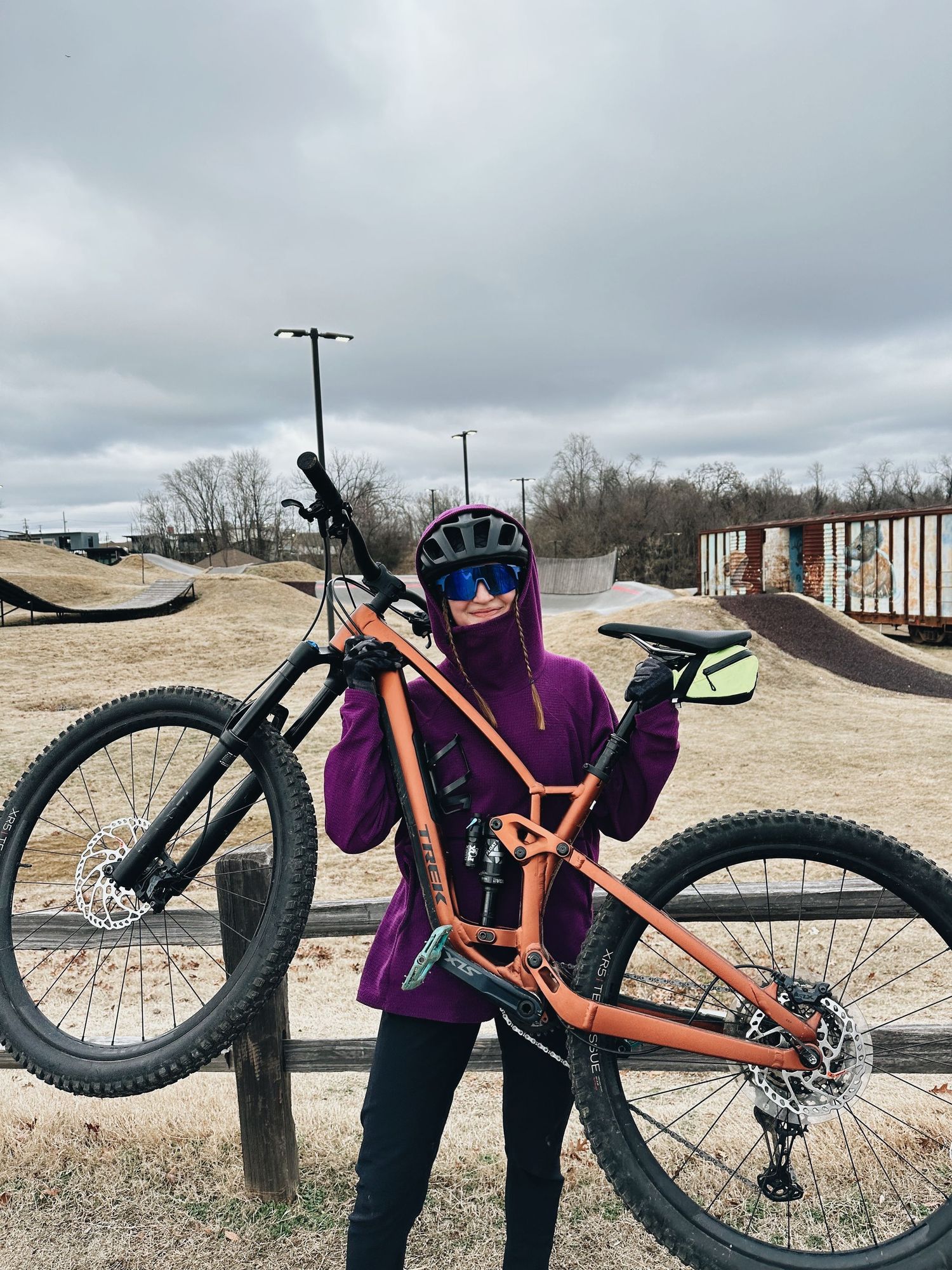 A series of close-up shots showing a bright orange fat tire mountain bike against a cloudy winter landscape.