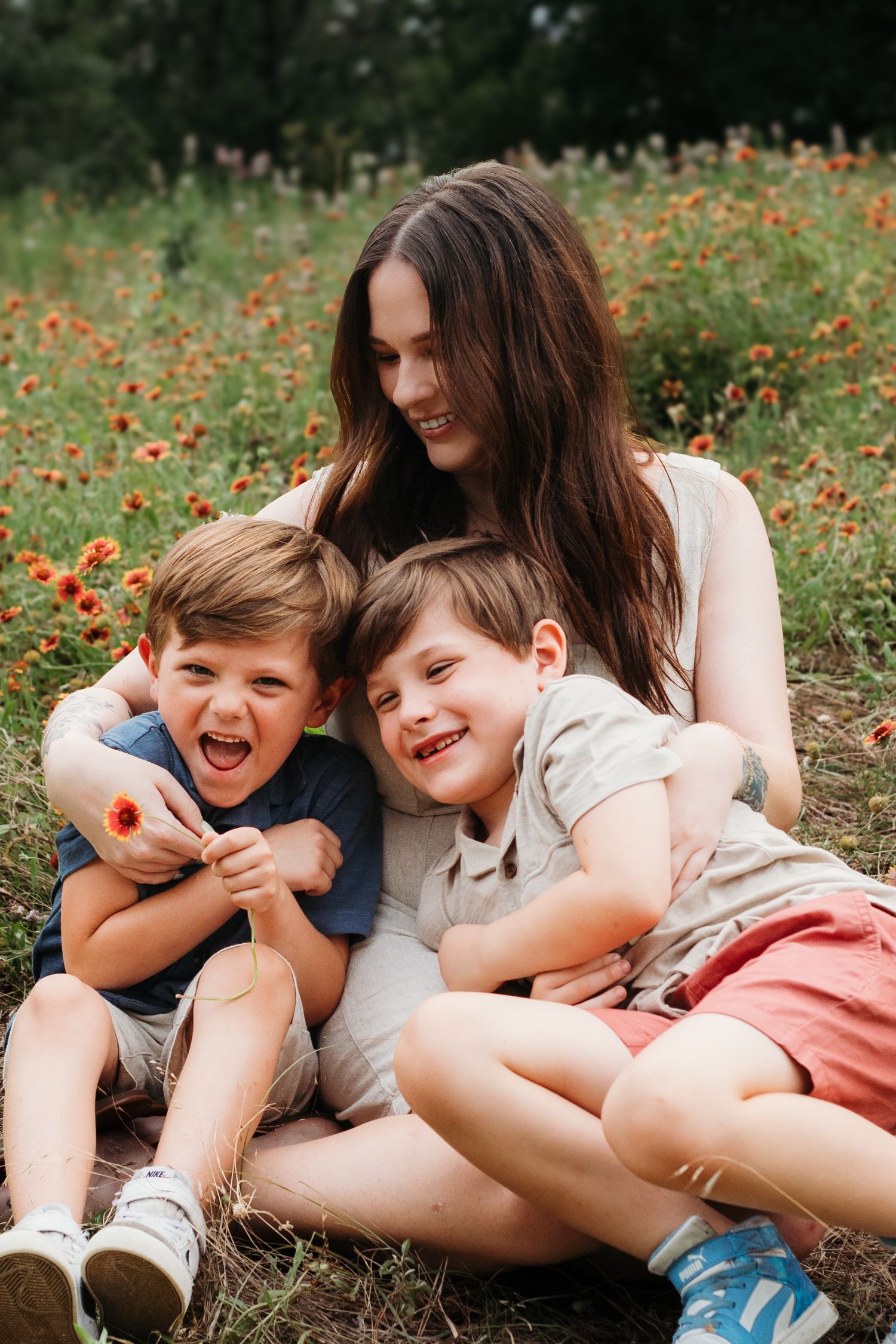 Joyful outdoor portrait in wildflower field with children laughing together.