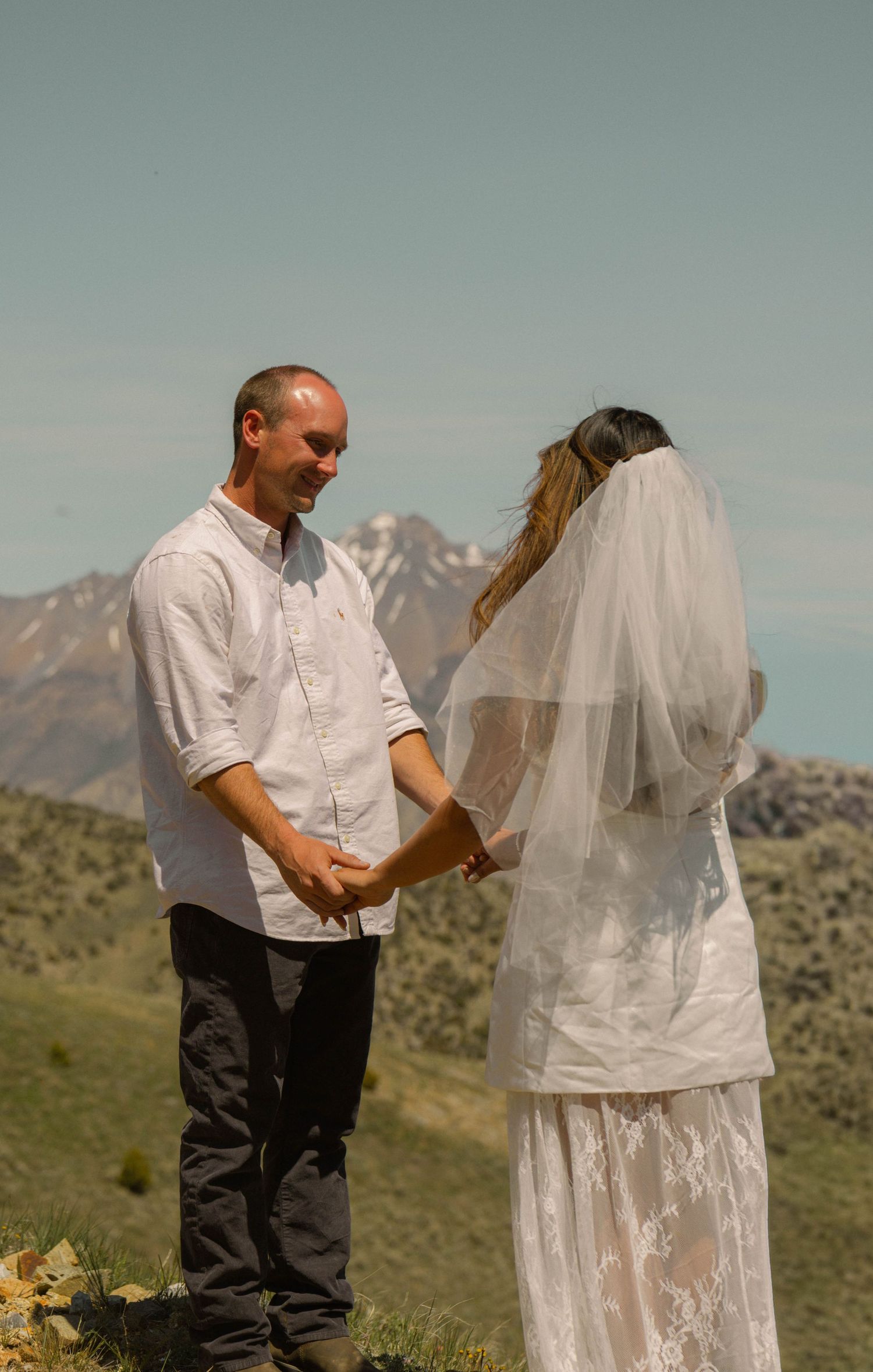 Couple exchanging vows outdoors with mountain backdrop during a scenic elopement ceremony.
