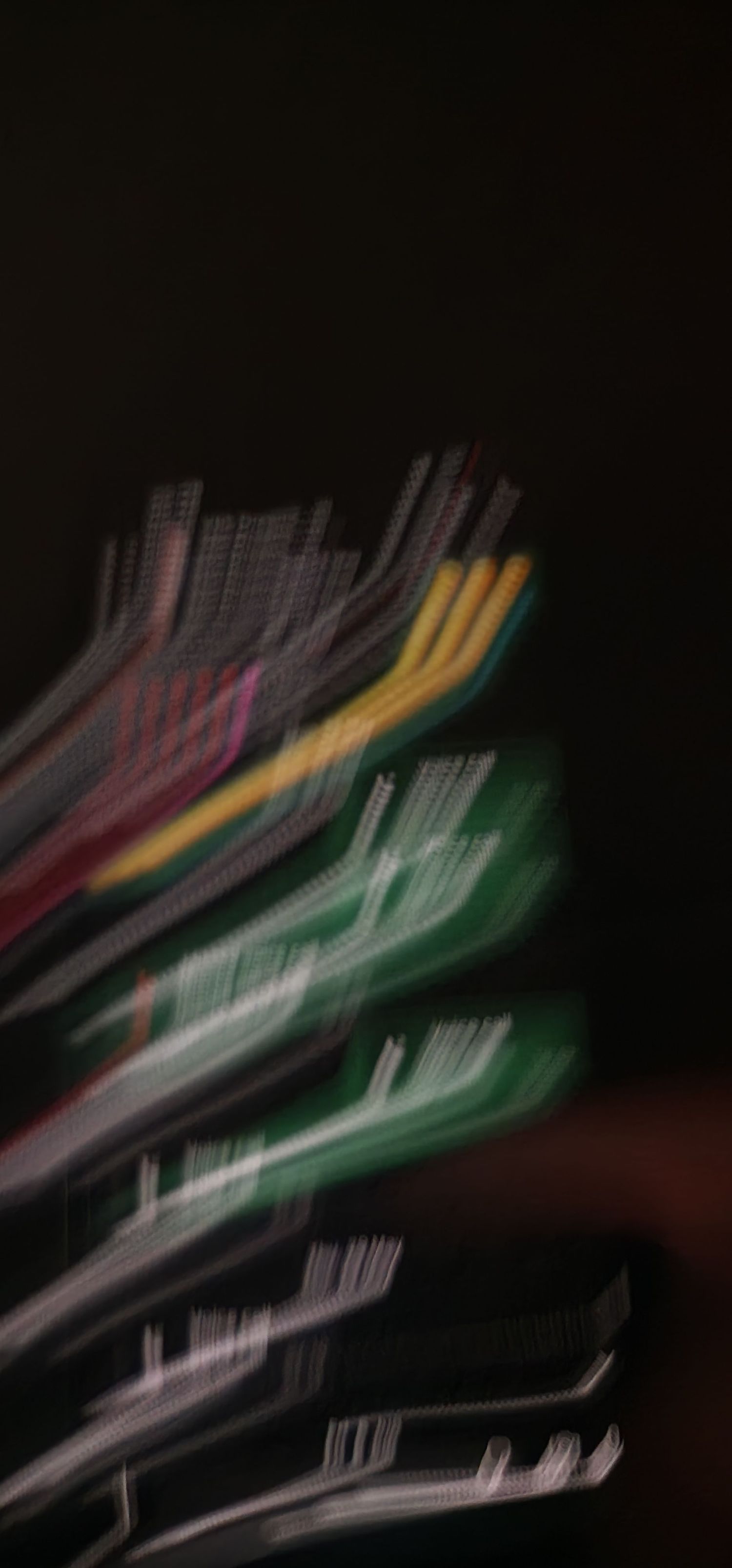 Blurred motion shot of colorful cables and wires against dark background.