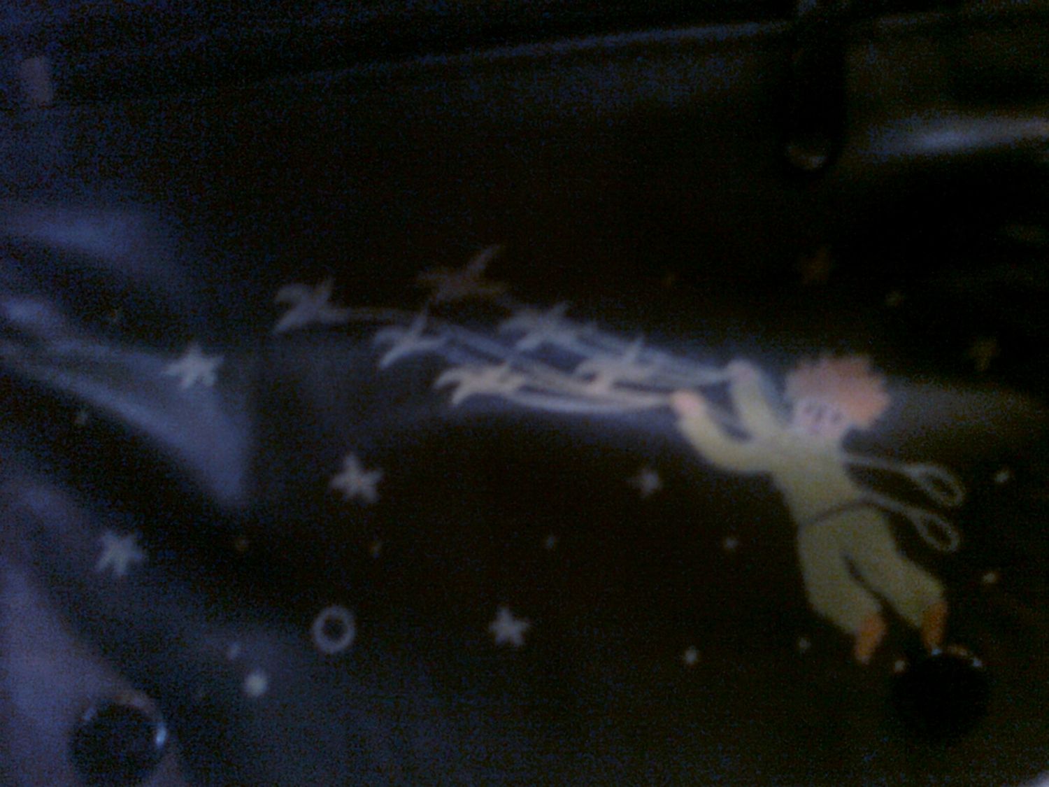 Dark artistic image of a glowing fairy figure surrounded by stars and sparkles on a dark background.
