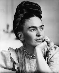 Classic black and white photo of a woman with an elegant braided updo and layered necklaces.