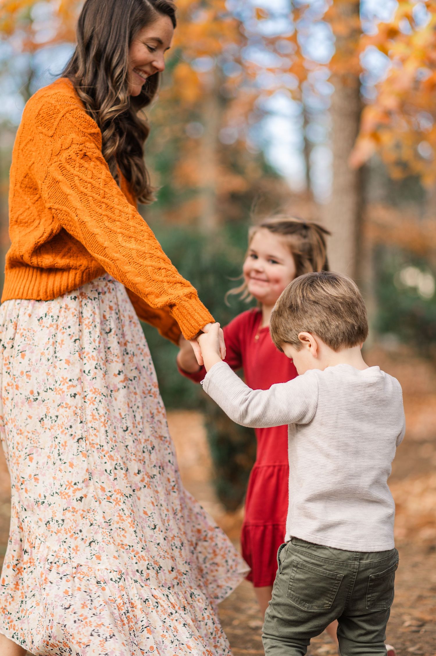 Dancing and twirling together in a fall setting with orange leaves.