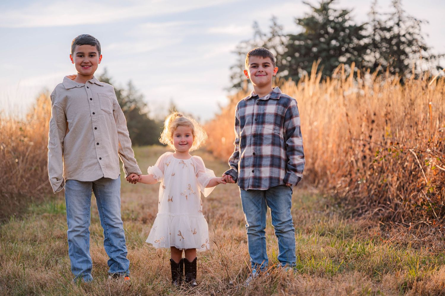 Casual outdoor family photos taken in a rustic field setting at dusk.