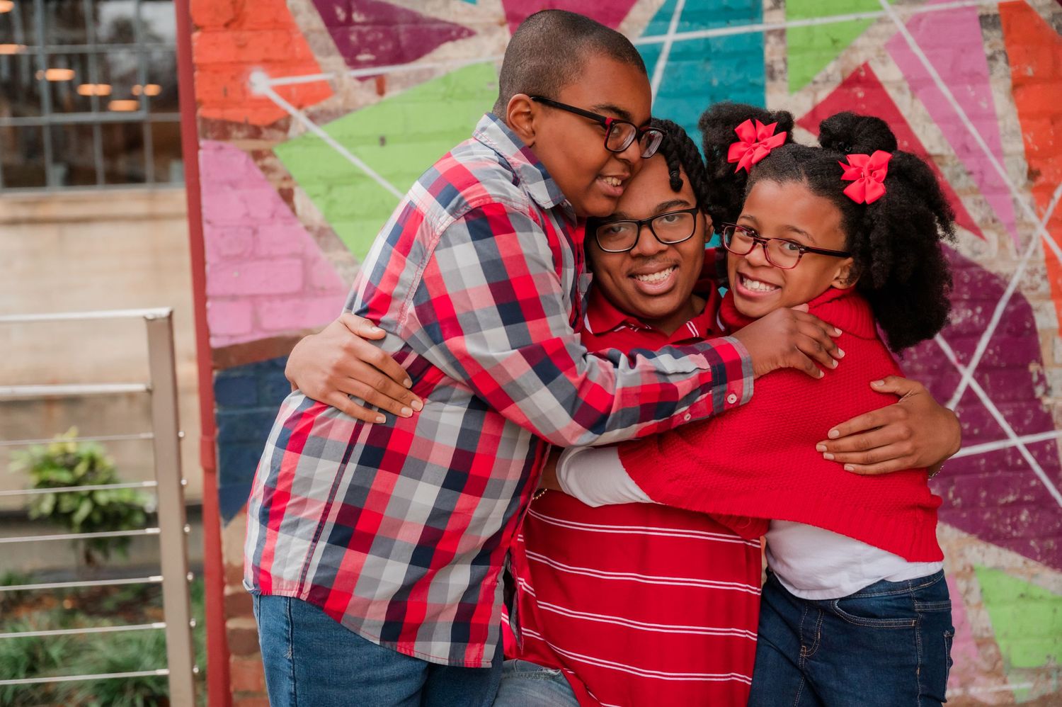 Colorful geometric patterned backdrop setting for indoor family photos with bright reds and pinks.
