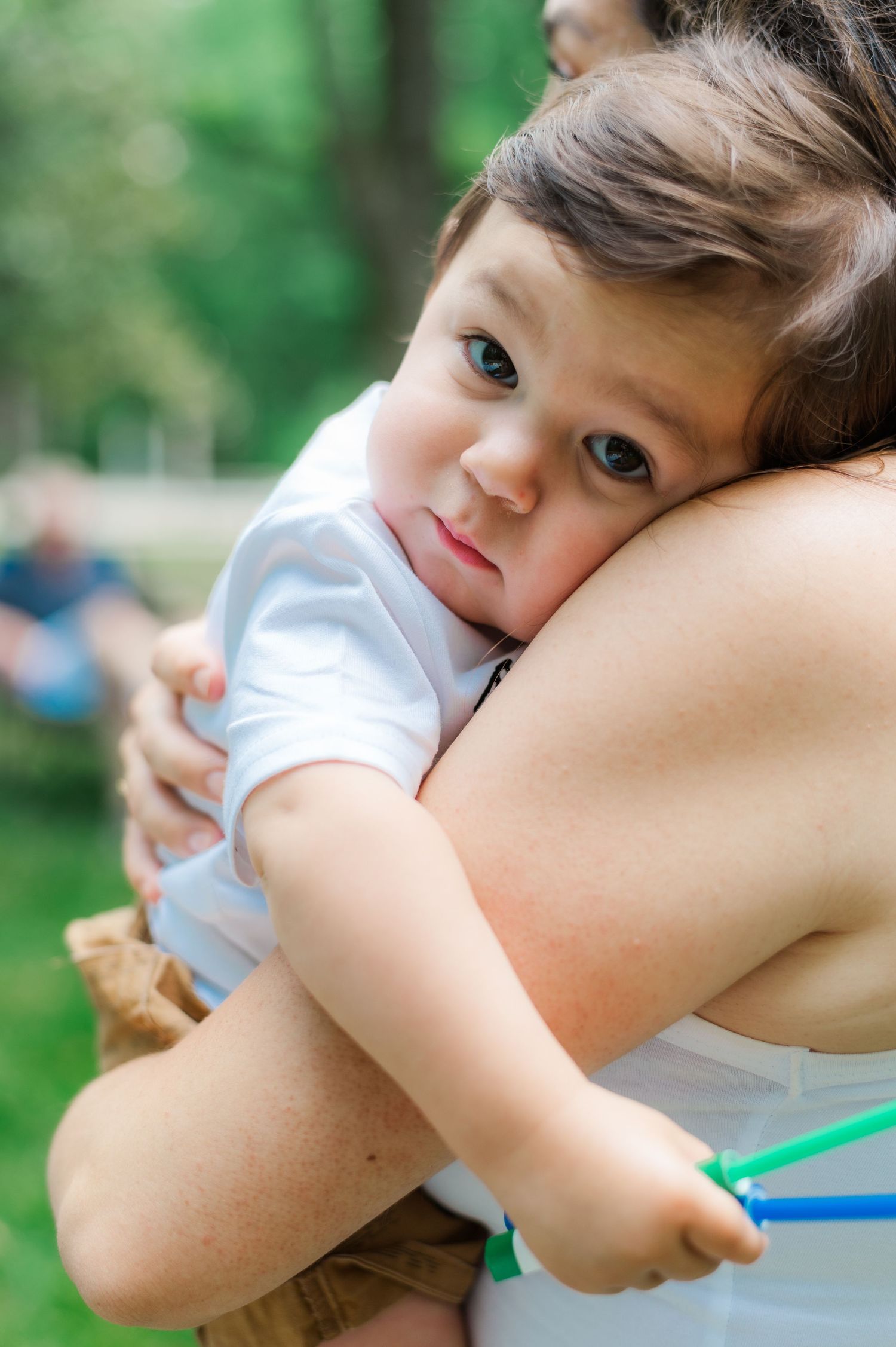 Close-up of child resting head on arm during outdoor photography session.