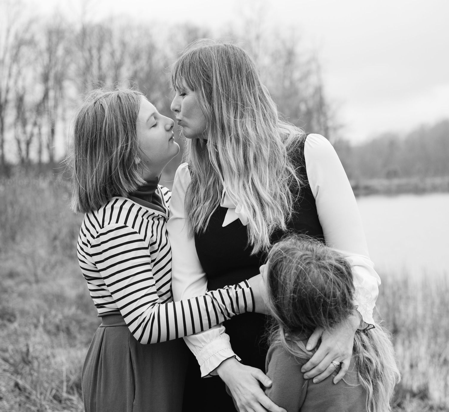 Black and white intimate family portraits captured in natural outdoor setting.